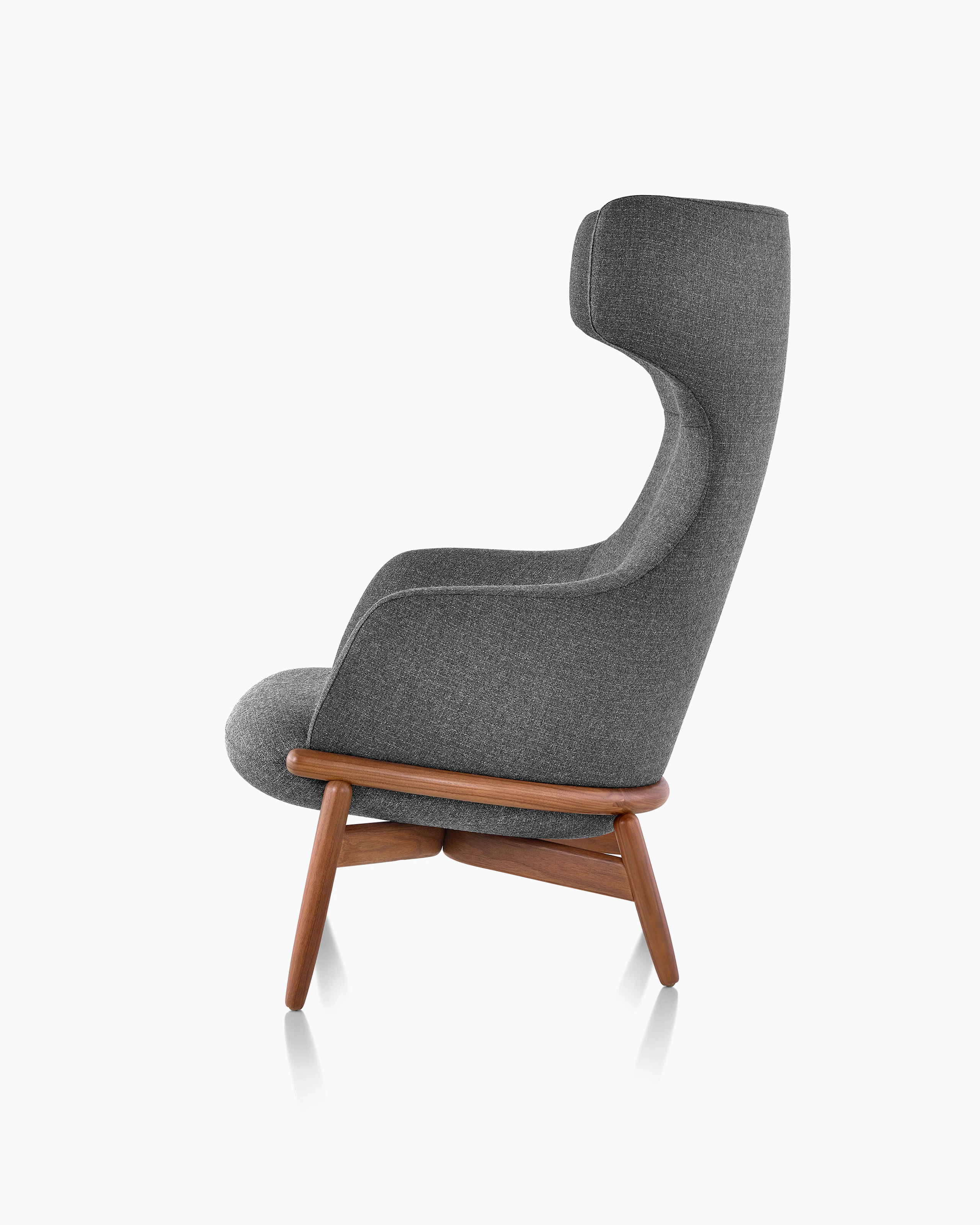 A wing-back Reframe Lounge Chair in Milaner Charcoal, viewed from the side.