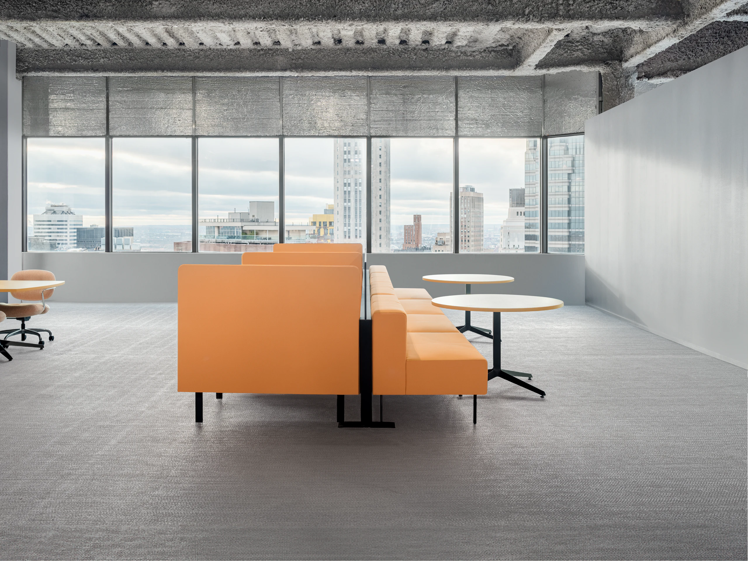 A group of working lounge seating is viewed from the side, showing how the same product can form two different work areas. The work areas are in an open office and in front of a large group of windows.