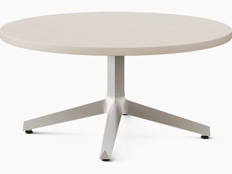 A three leg occasional table is shown in a light color veneer and light paint on the base.