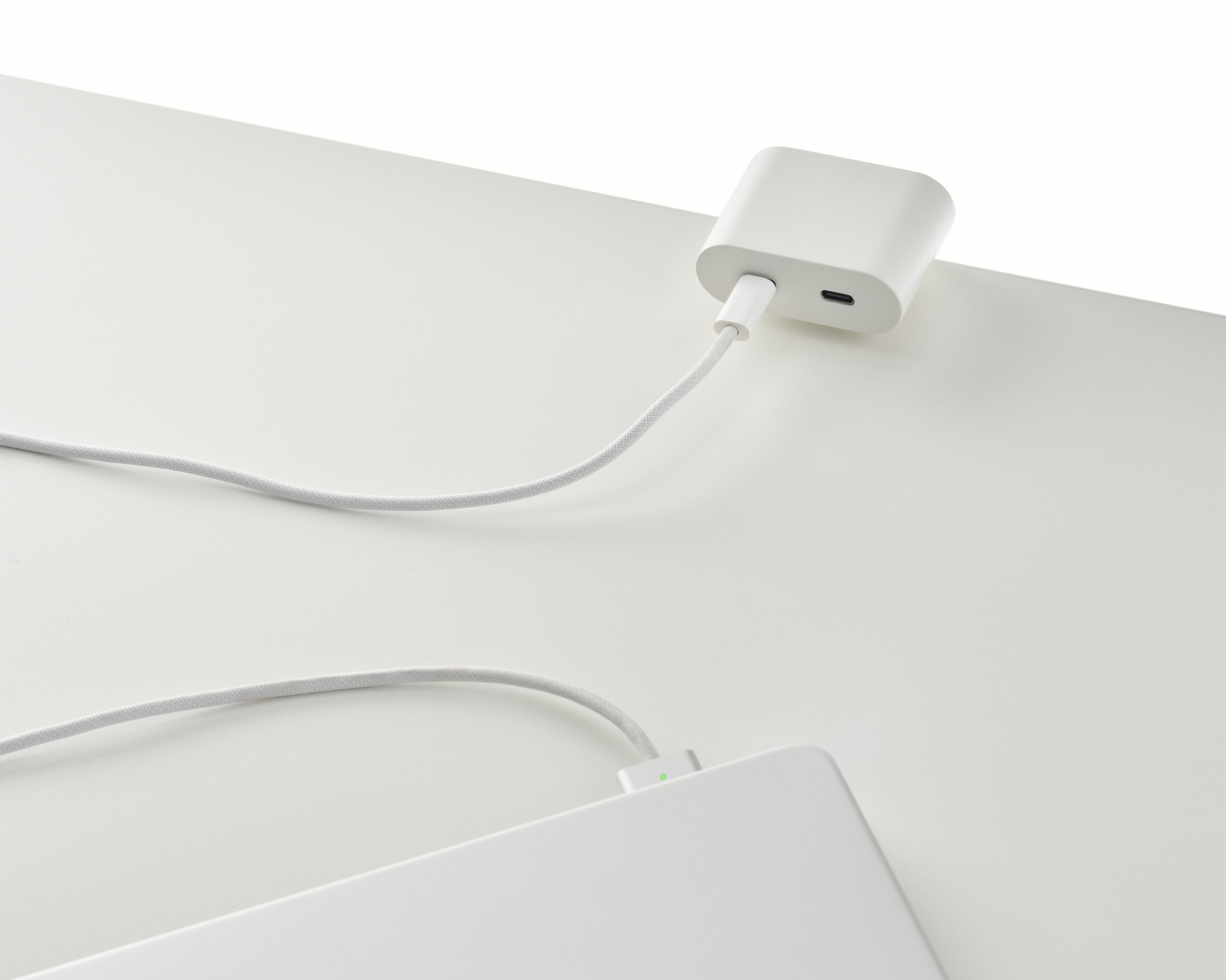 Clamp on USB-C power solution shown in white charging a laptop.