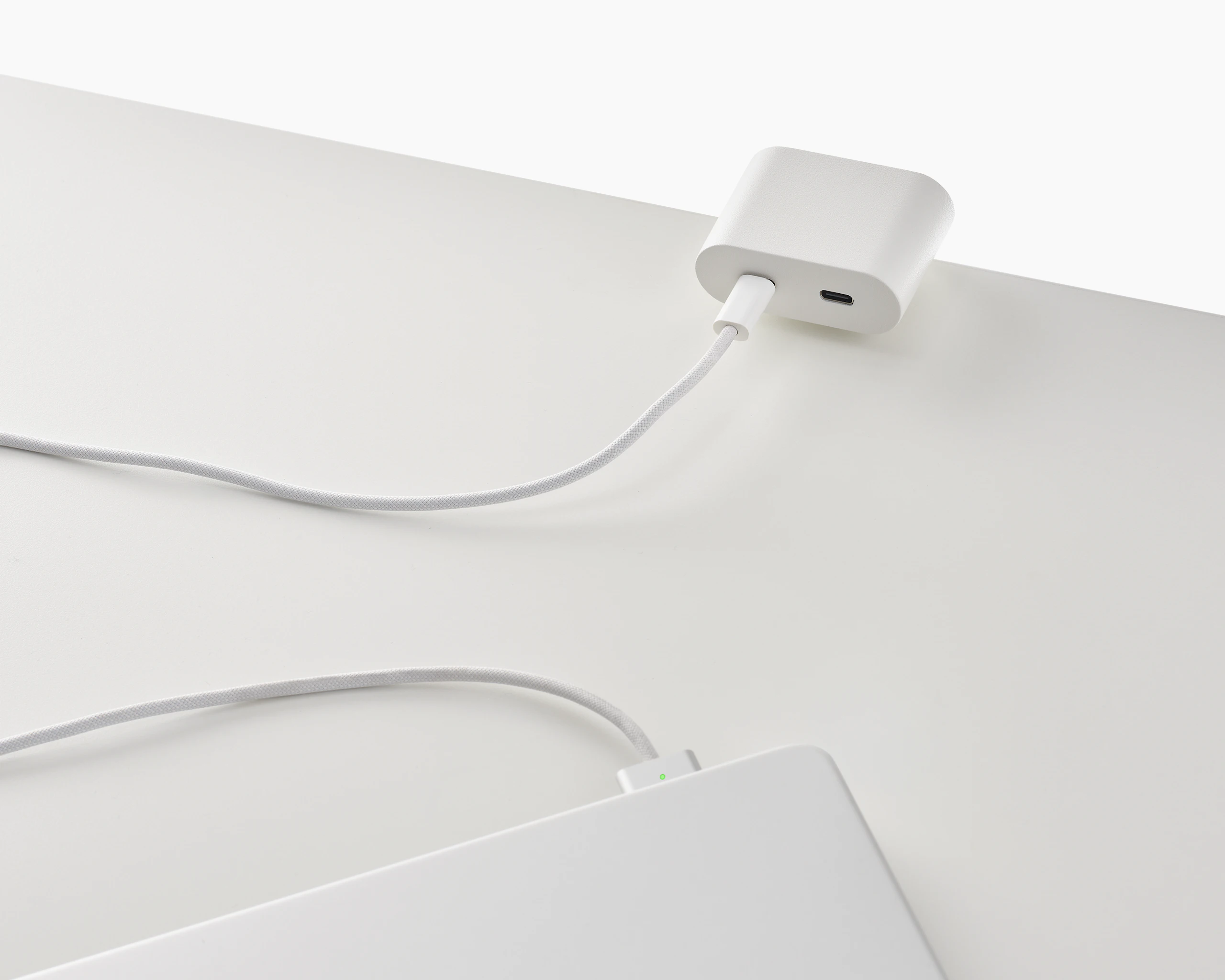 Clamp on USB-C power solution shown in white charging a laptop.