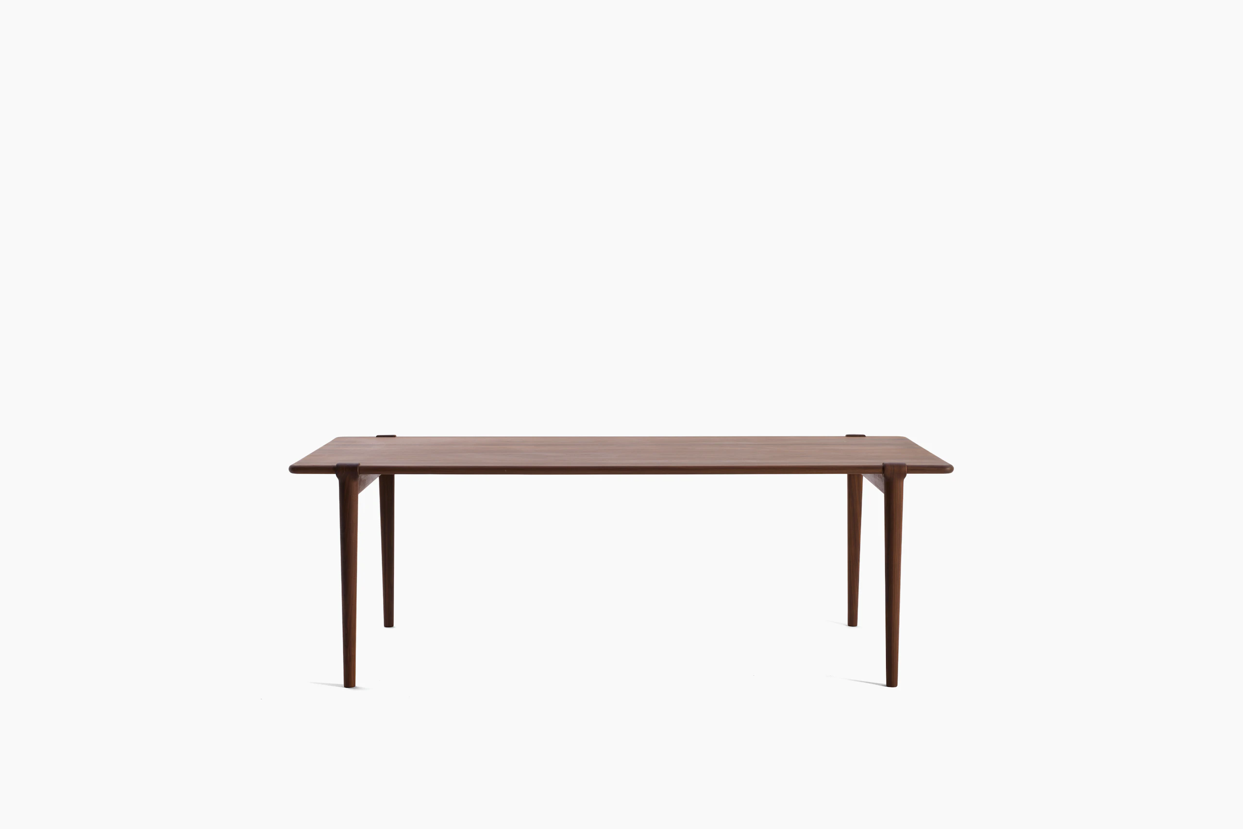 An Otto Dining Table in Walnut viewed from the front.