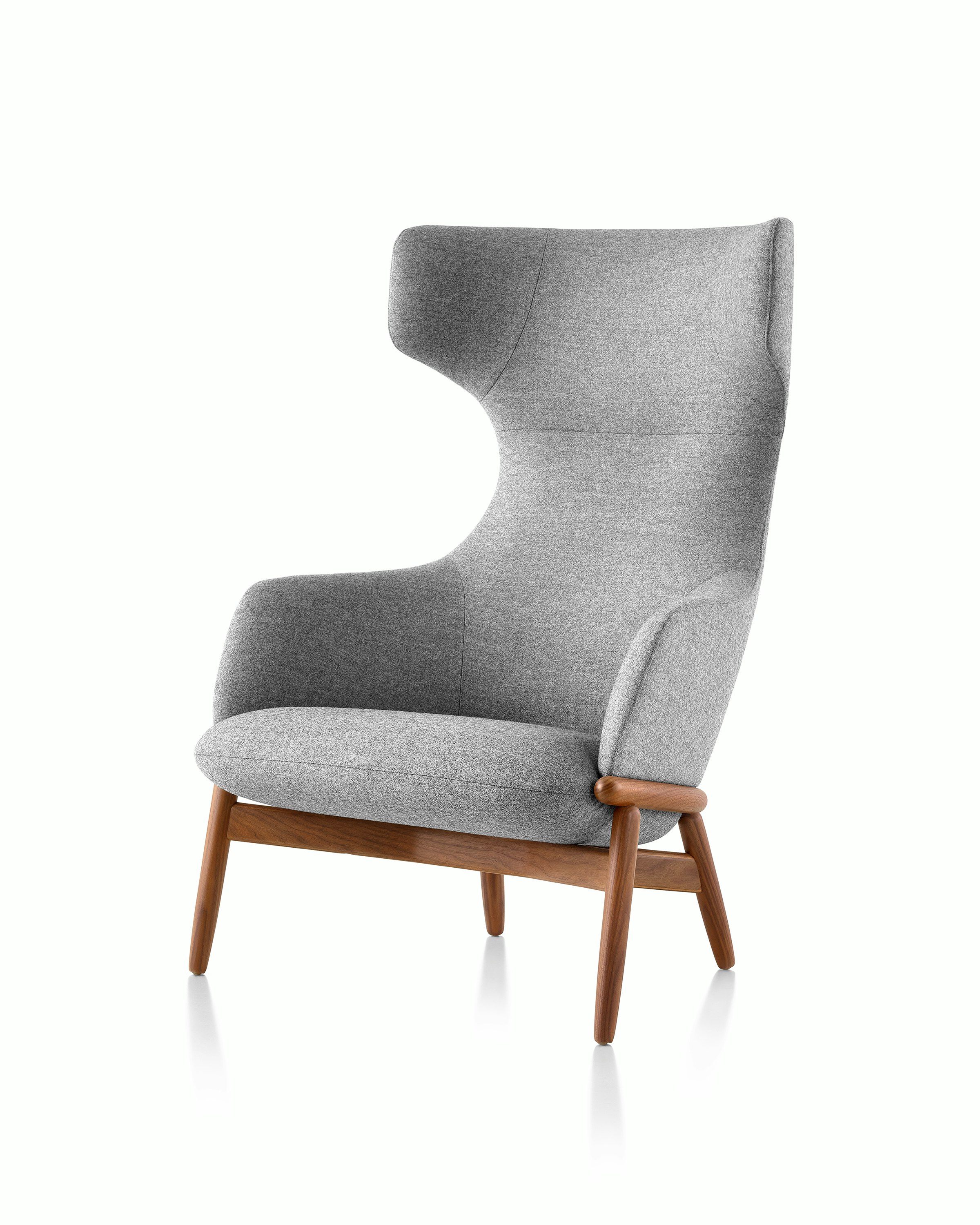 Angled view of a wing-back Reframe lounge chair with light gray upholstery and a wood frame with a medium finish.