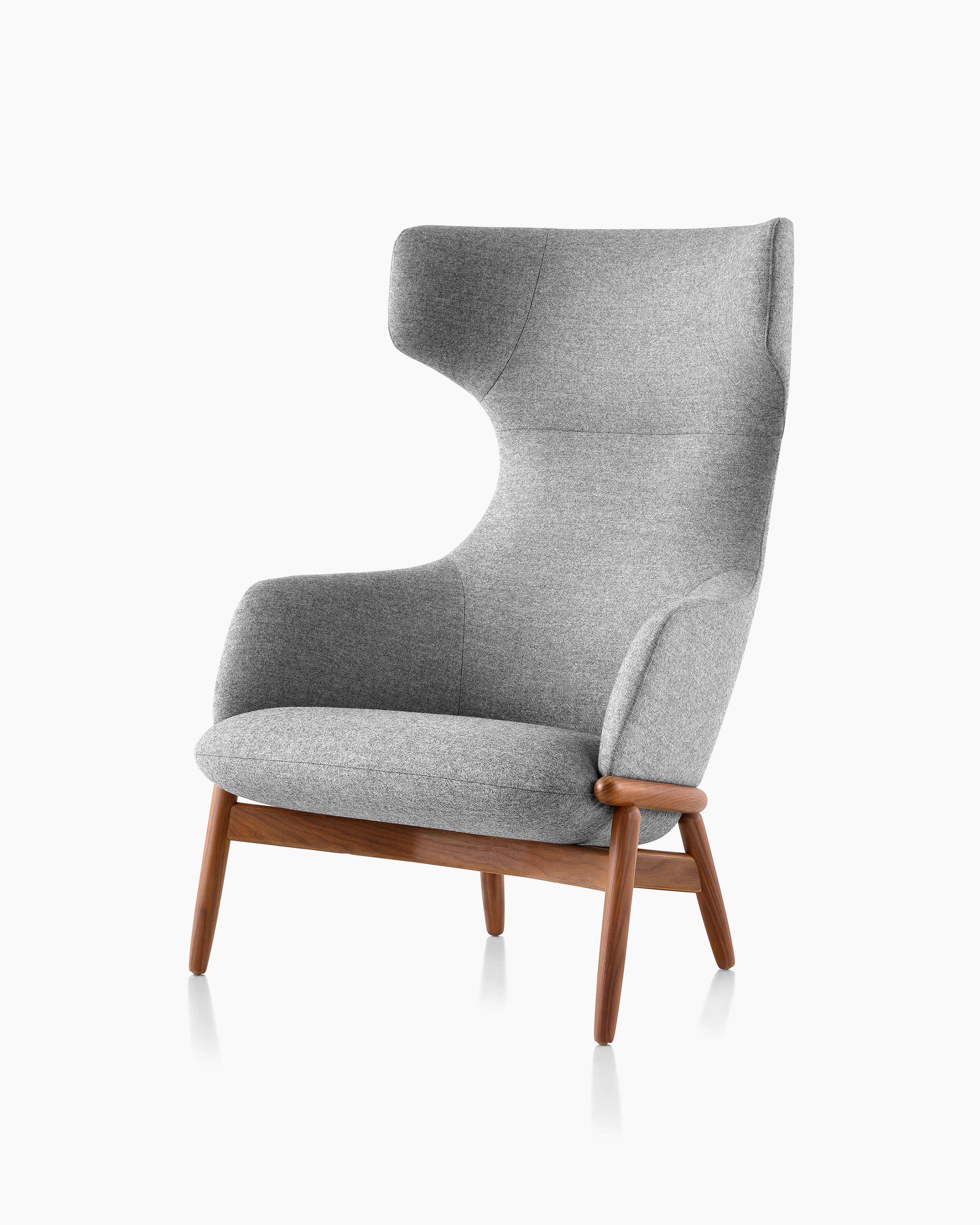 Angled view of a wing-back Reframe lounge chair with light gray upholstery and a wood frame with a medium finish.