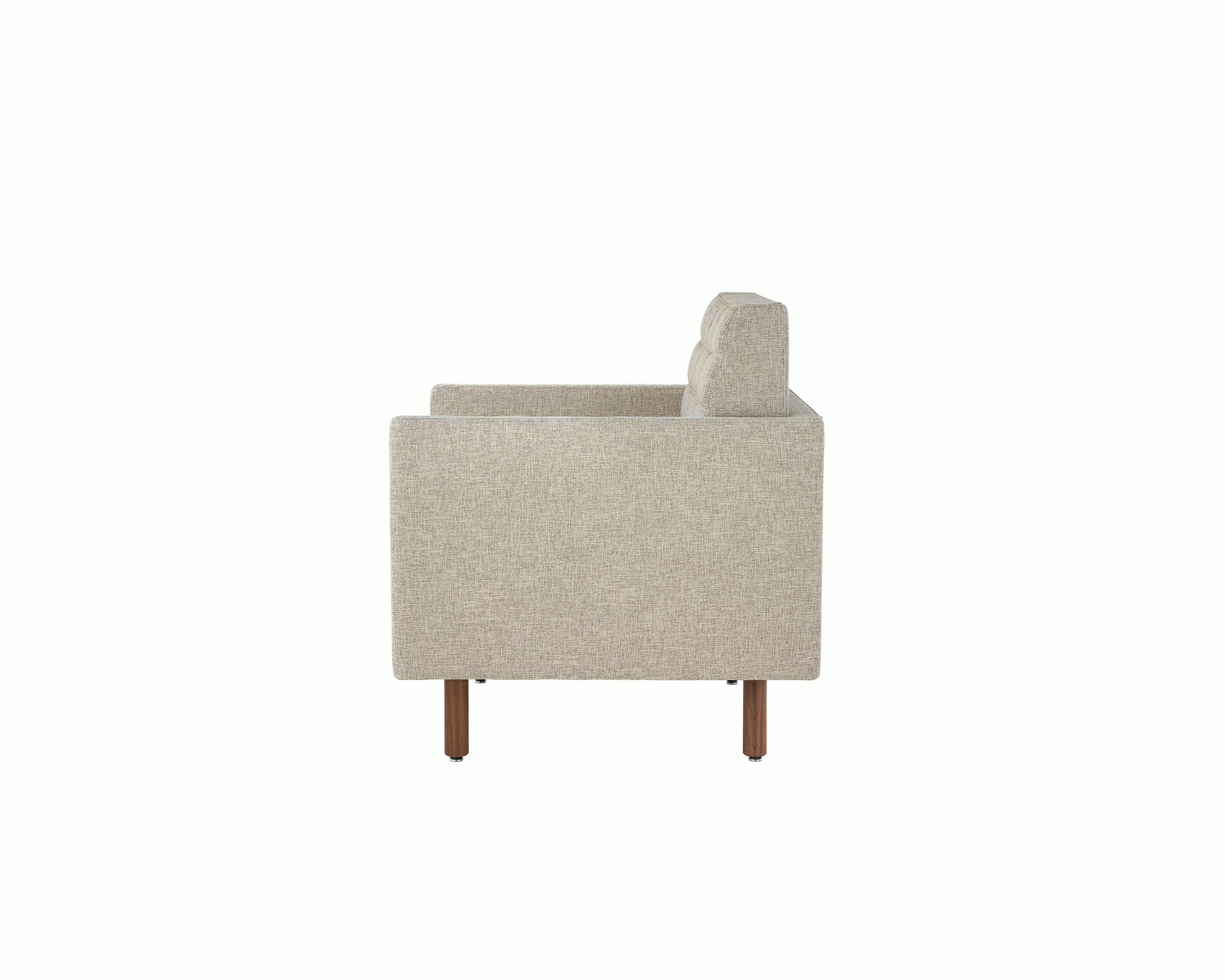Profile view of a quilted Tuxedo Classic club chair upholstered in bone-colored fabric.