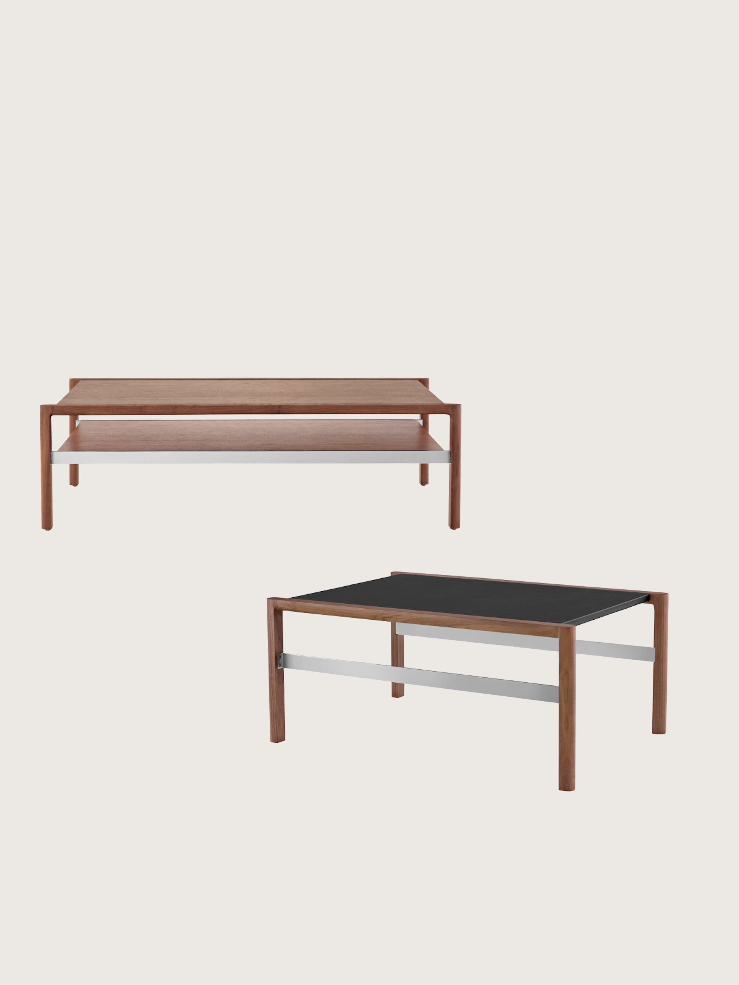 Two Brabo Tables designed by Vincent Van Duysen, one front-facing in a medium wood finish with a lower shelf, one in a medium wood finish with a black, leather-wrapped top shown at an angle and staggered below the other, on a white sweep.