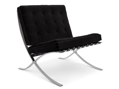 A front three quarter view of an Ebony Knoll Velvet Barcelona Chair by Knoll with a polished chrome frame on a white background