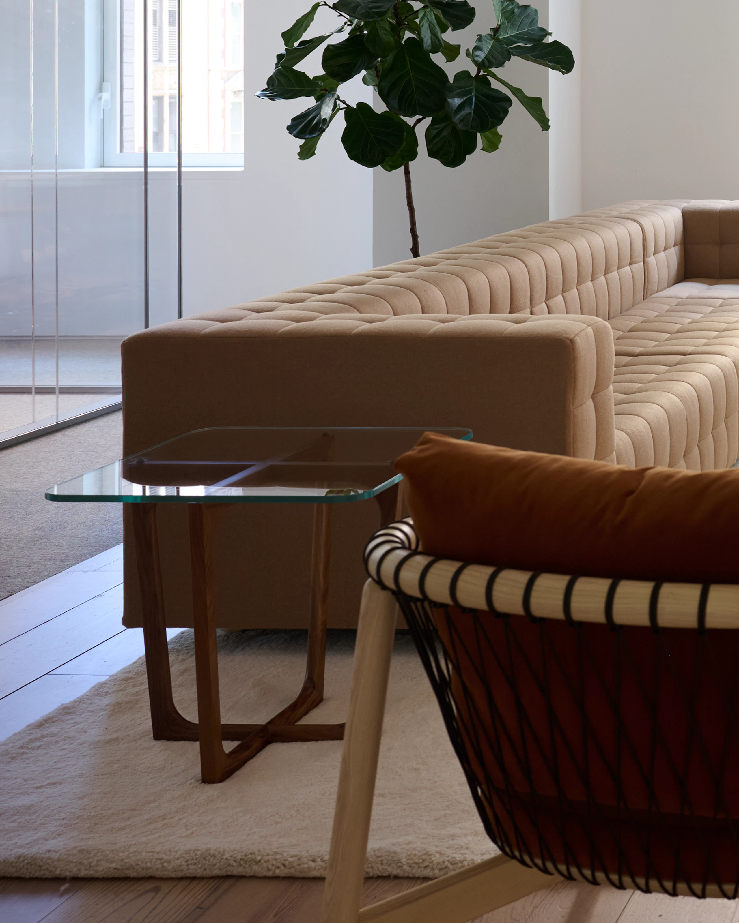 Lounge setting with a Rapport Sectional Sofa, Crosshatch Lounge Chair, and Loophole Table.