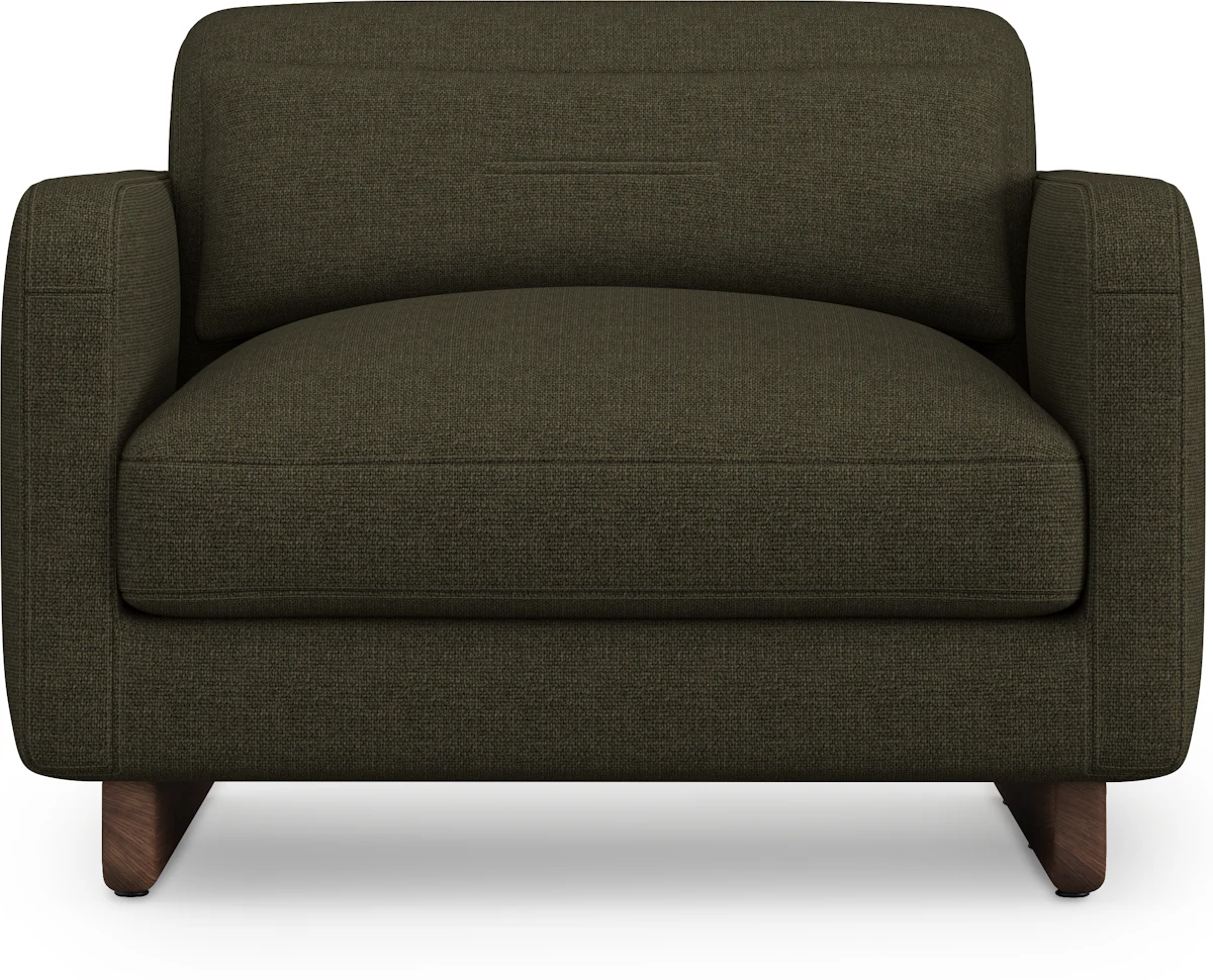 Close-up of armrest and cushion on a rust-colored sofa with wooden base.
