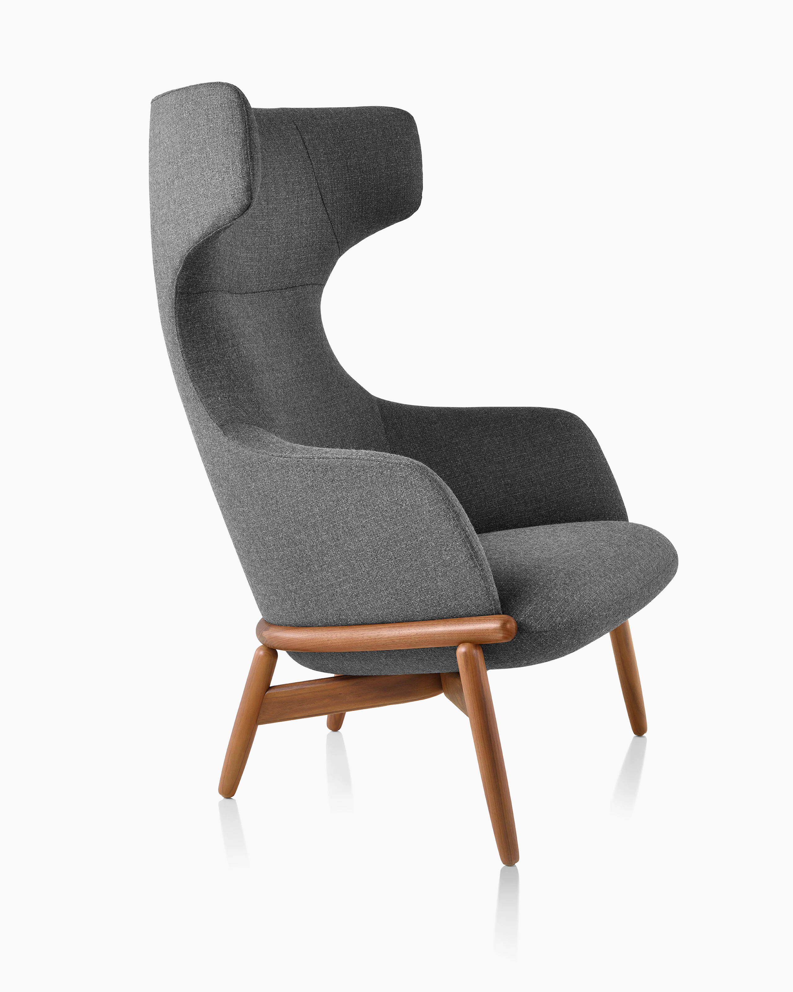 A wing-back Reframe Lounge Chair in Milaner Charcoal viewed from the side.