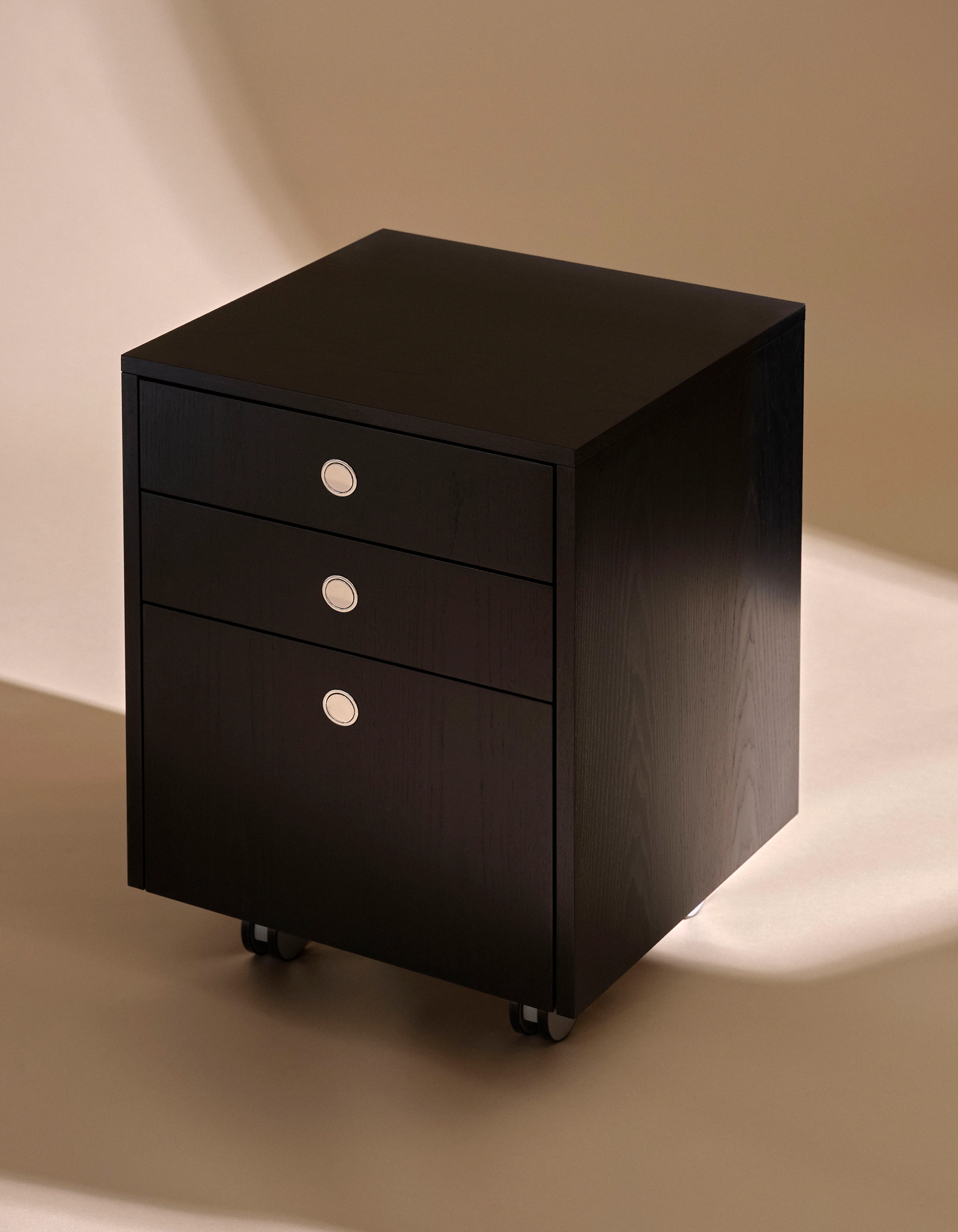Sled Base Pedestal with casters designed by Ward Bennett in Ebonized Ash with chrome metal pulls, shown at an angle against a neutral studio background.
