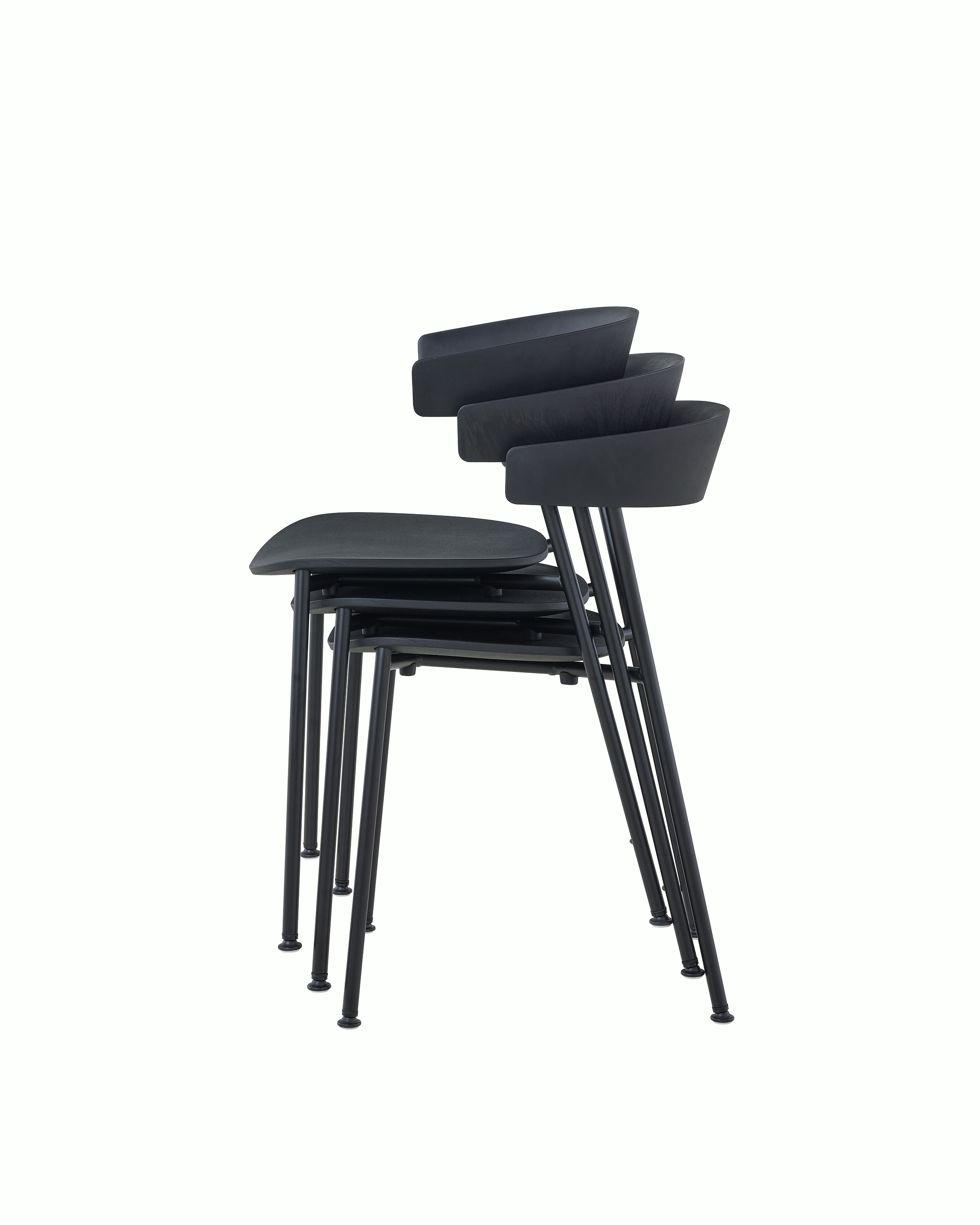 A profile view of black Leeway Chairs stacked three high.