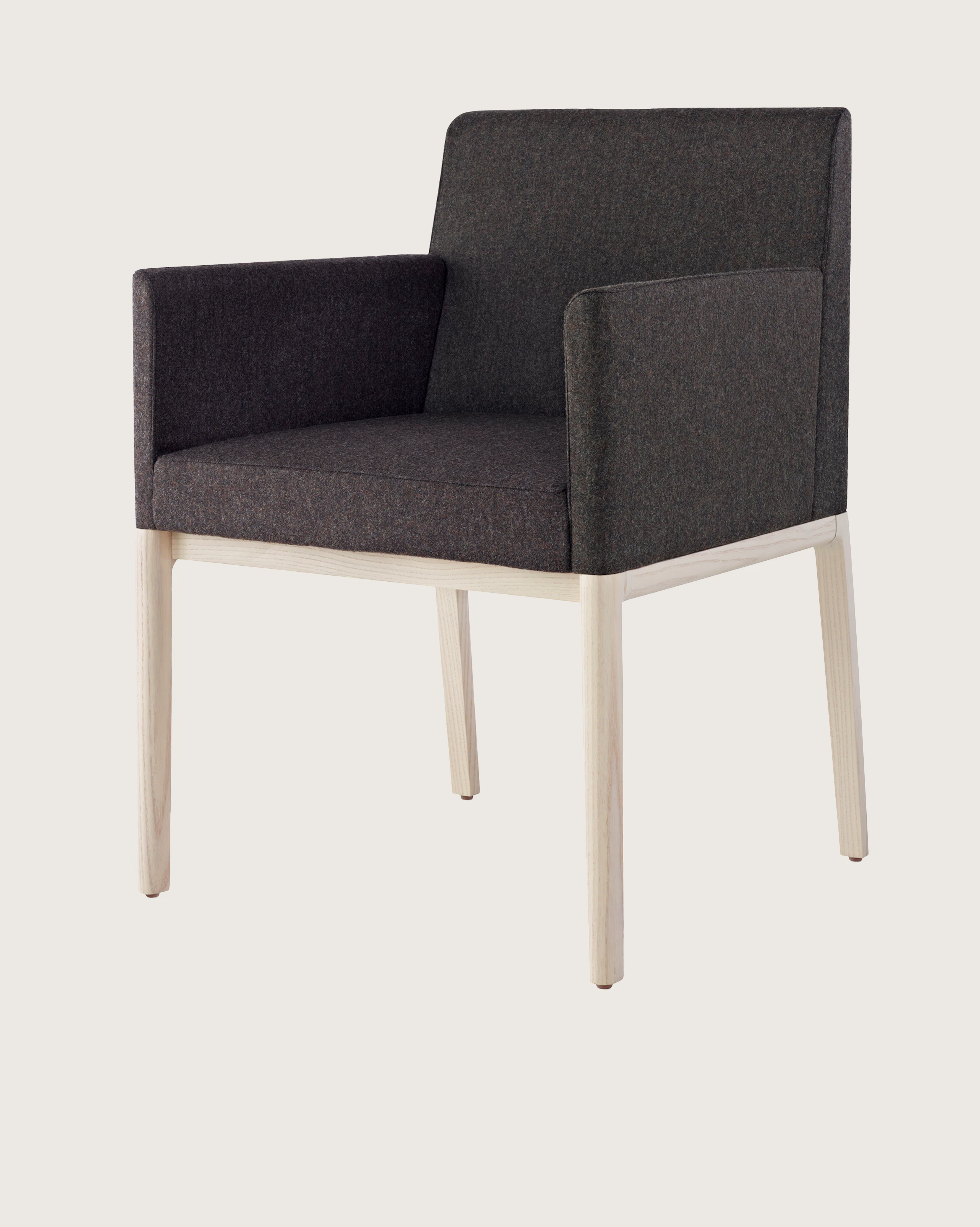 Angled view of a Nessel side chair with wraparound arms, showing the precision upholstery and wood craftsmanship.