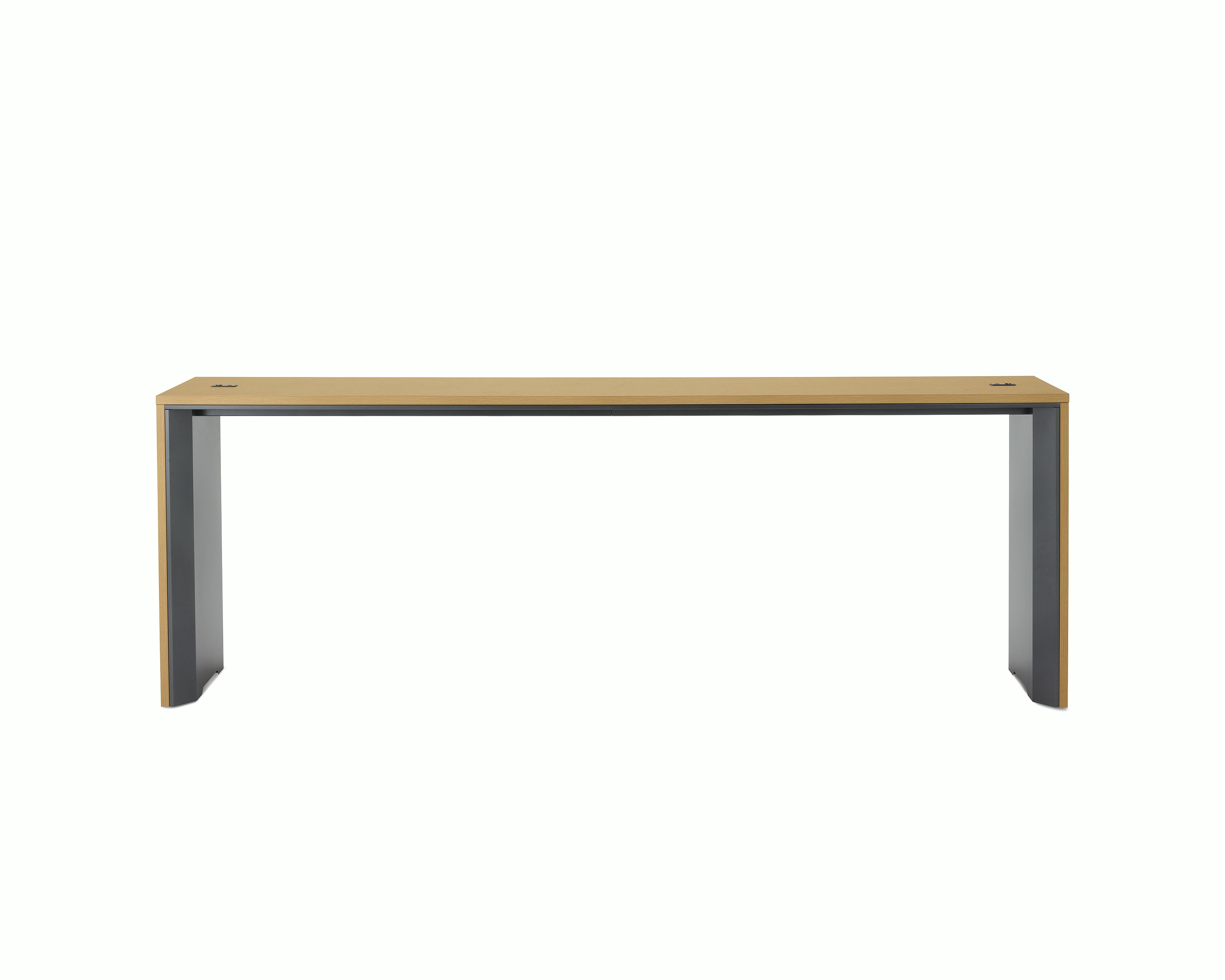 A narrow communal Headway table at standing height with a medium light wood top and dark gray base.