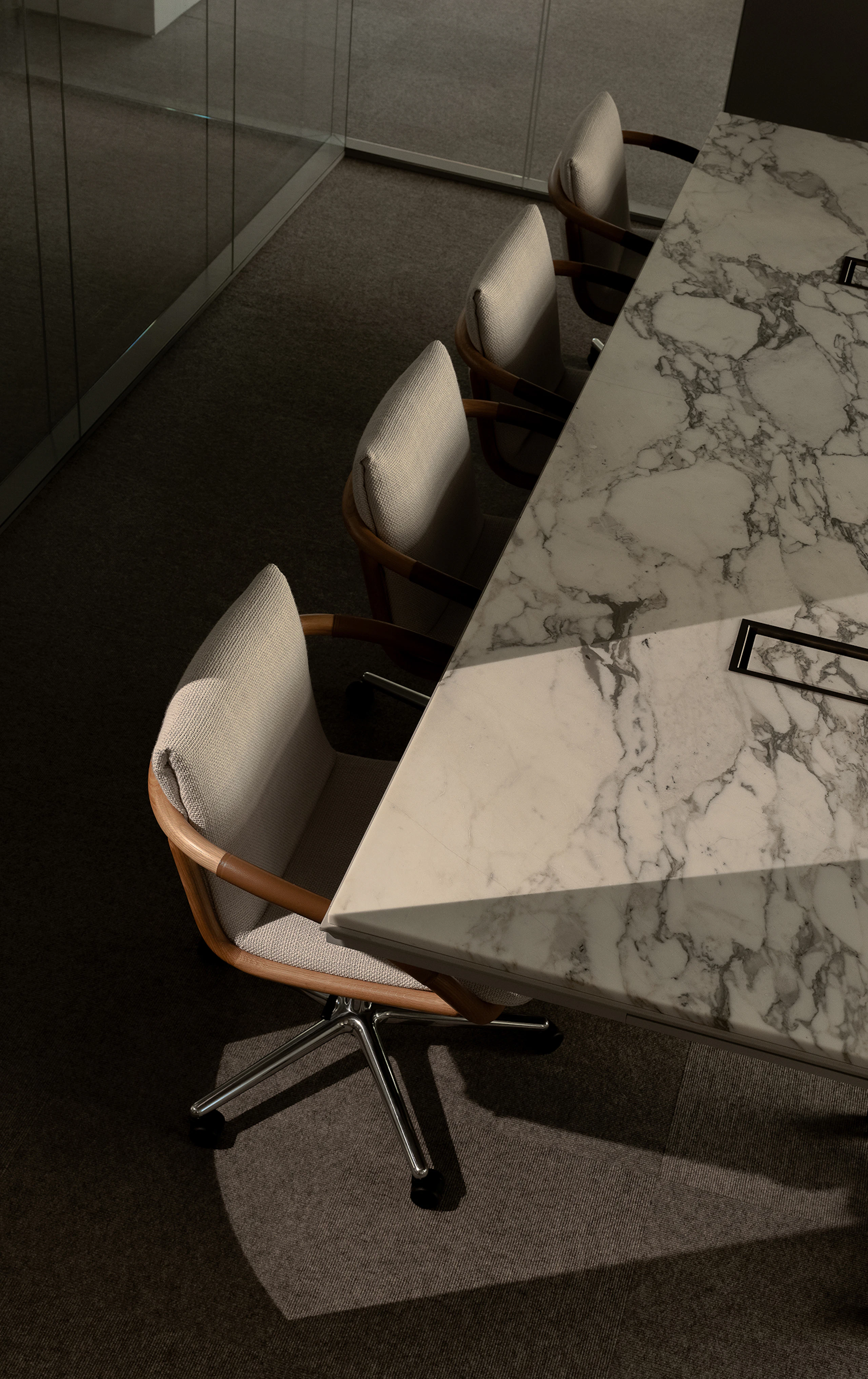 Angled view of Full Loop Chairs in Natural Oak upholstered with Capri textile in Snow around a Highline Conference Table with an Arabescato Corchia Marble tabletop in a conference room setting.