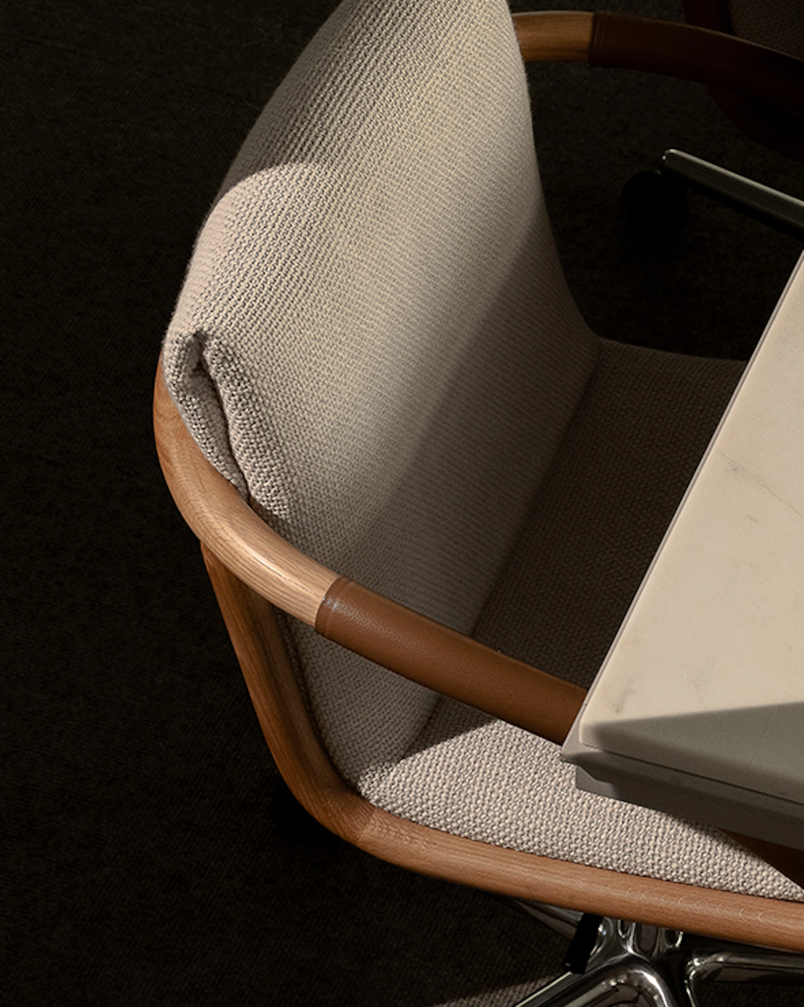 Angled view of Full Loop Chairs in Natural Oak upholstered with Capri textile in Snow around a Highline Conference Table with an Arabescato Corchia Marble tabletop in a conference room setting.