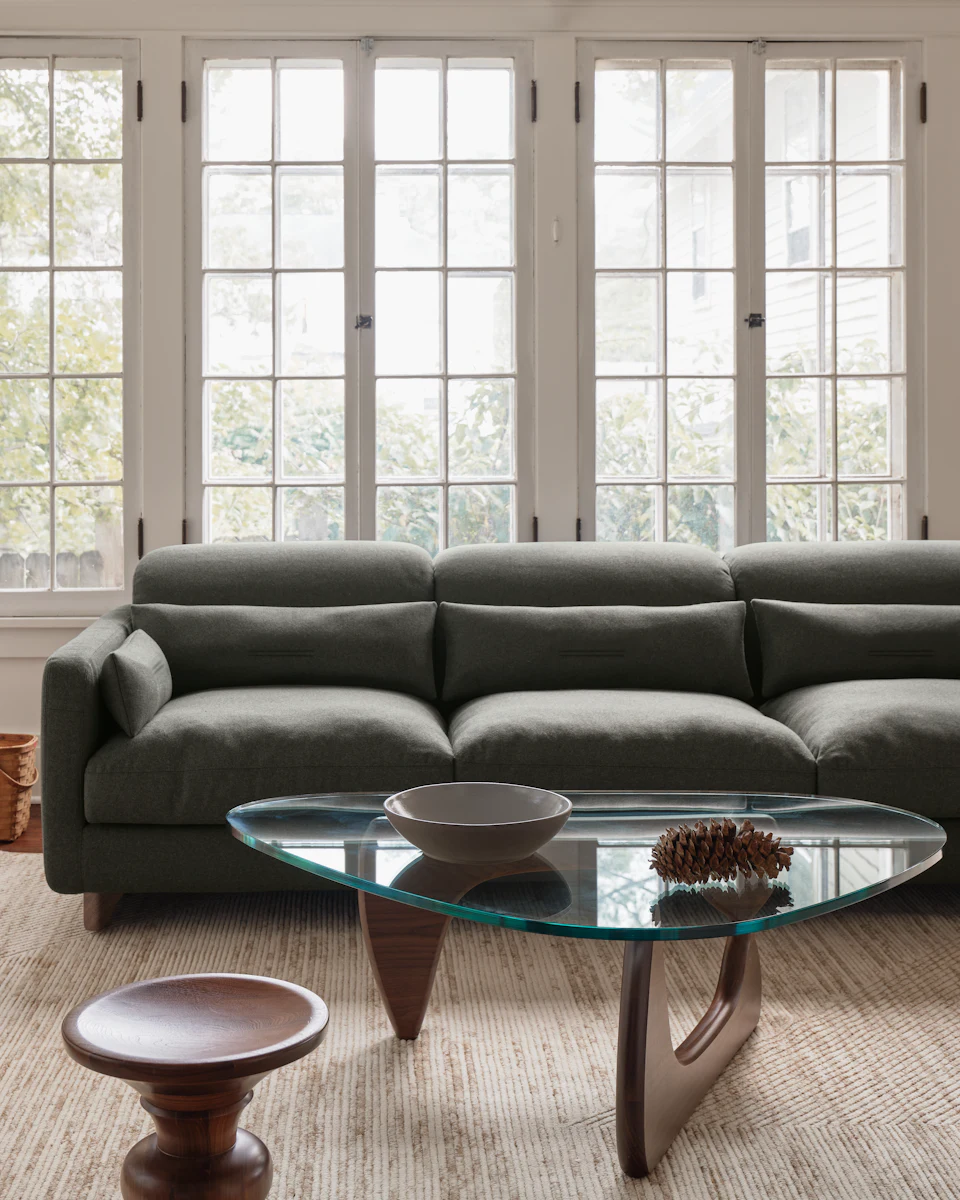 Living room scene featuring the sofa with windows and glass coffee table