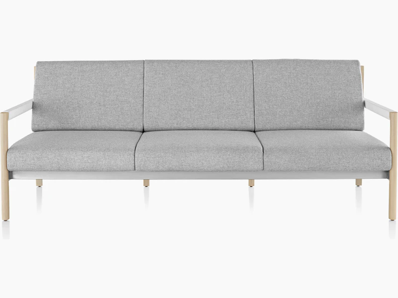 A Brabo sofa with Clare light gray upholstery, white leather-wrapped arms, metal accents, and a light wood frame, viewed from the front.