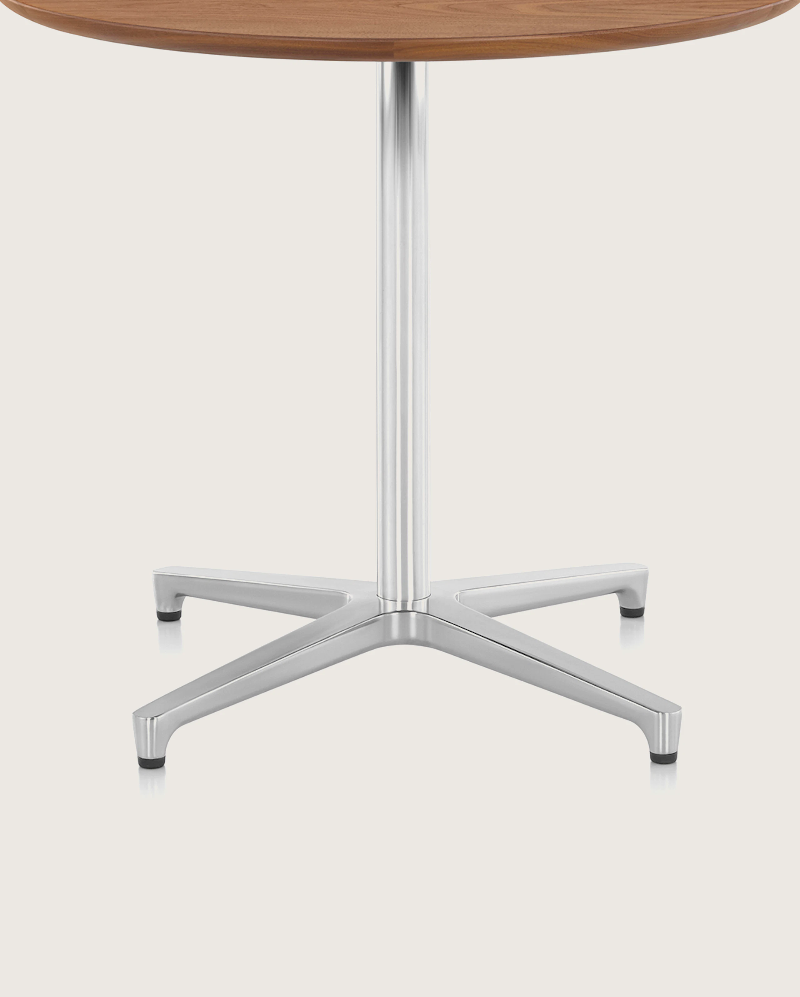 Close-up of the aluminum pedestal base on a round Saiba occasional table.