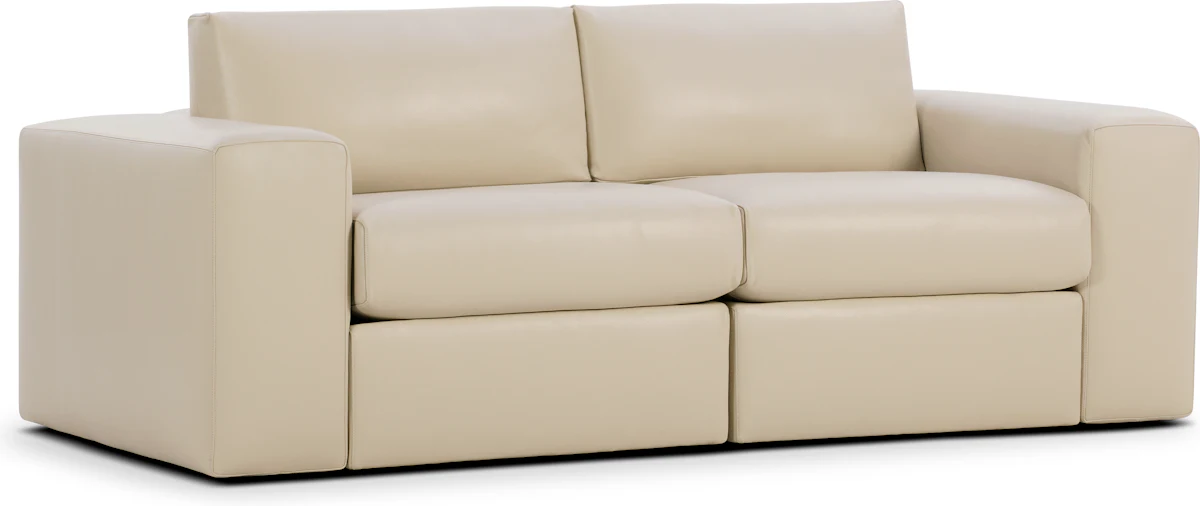 A cream-colored ottoman-style sofa with wide armrests and two-seat cushions.