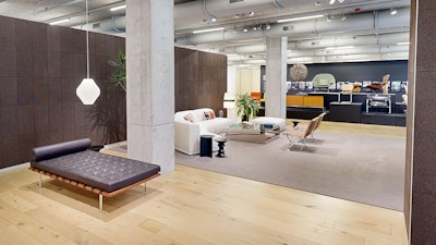A large platform bench, white sofa, coffee table, and chairs in a seating display at the MillerKnoll showroom at 1100 West Fulton Market during Design Days. The MillerKnoll Archives display lines the wall in the background.