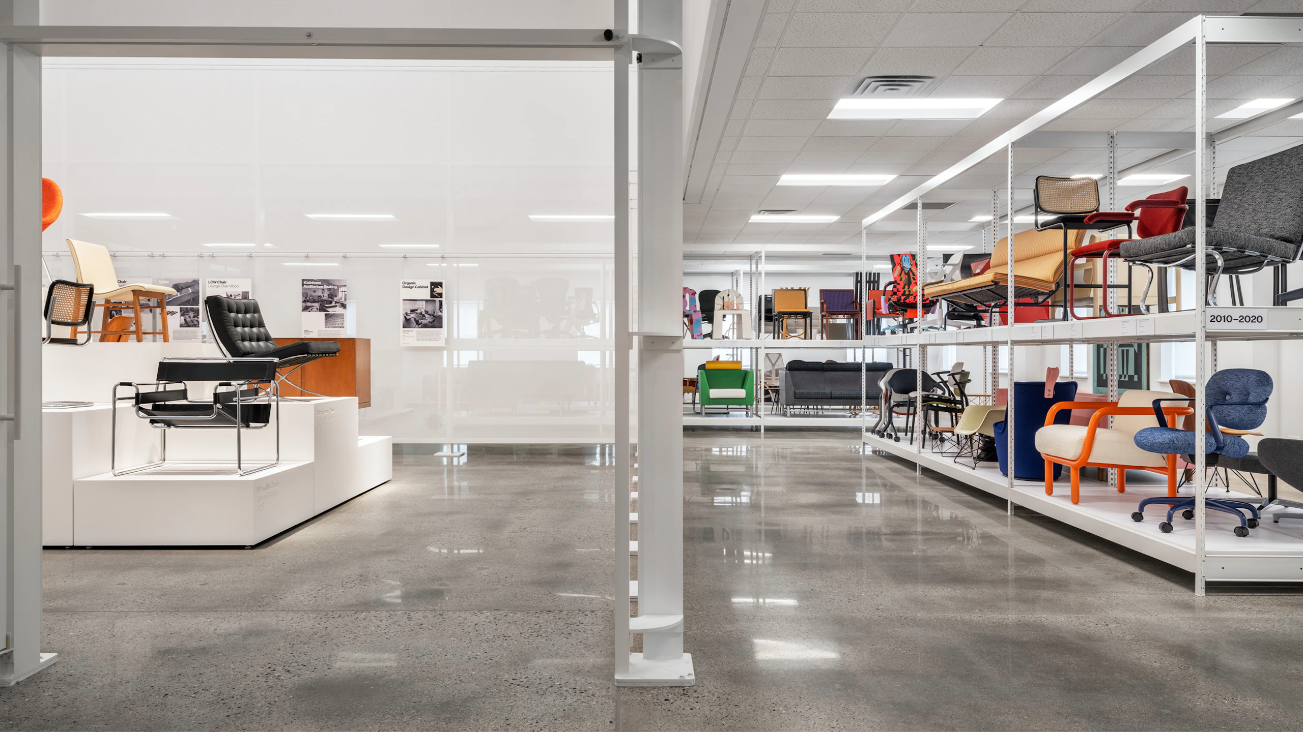 A split view of the MillerKnoll Archives showing pedestals about iconic pieces of the collective in one room and rows of white shelves displaying a range of furniture from MillerKnoll in another