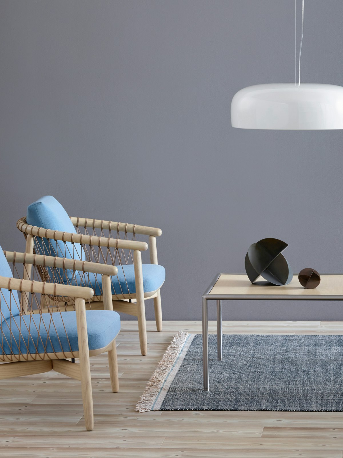 Two Crosshatch lounge chairs with light blue fabric and light wood frames; positioned next to a rectangular Full Round coffee table.