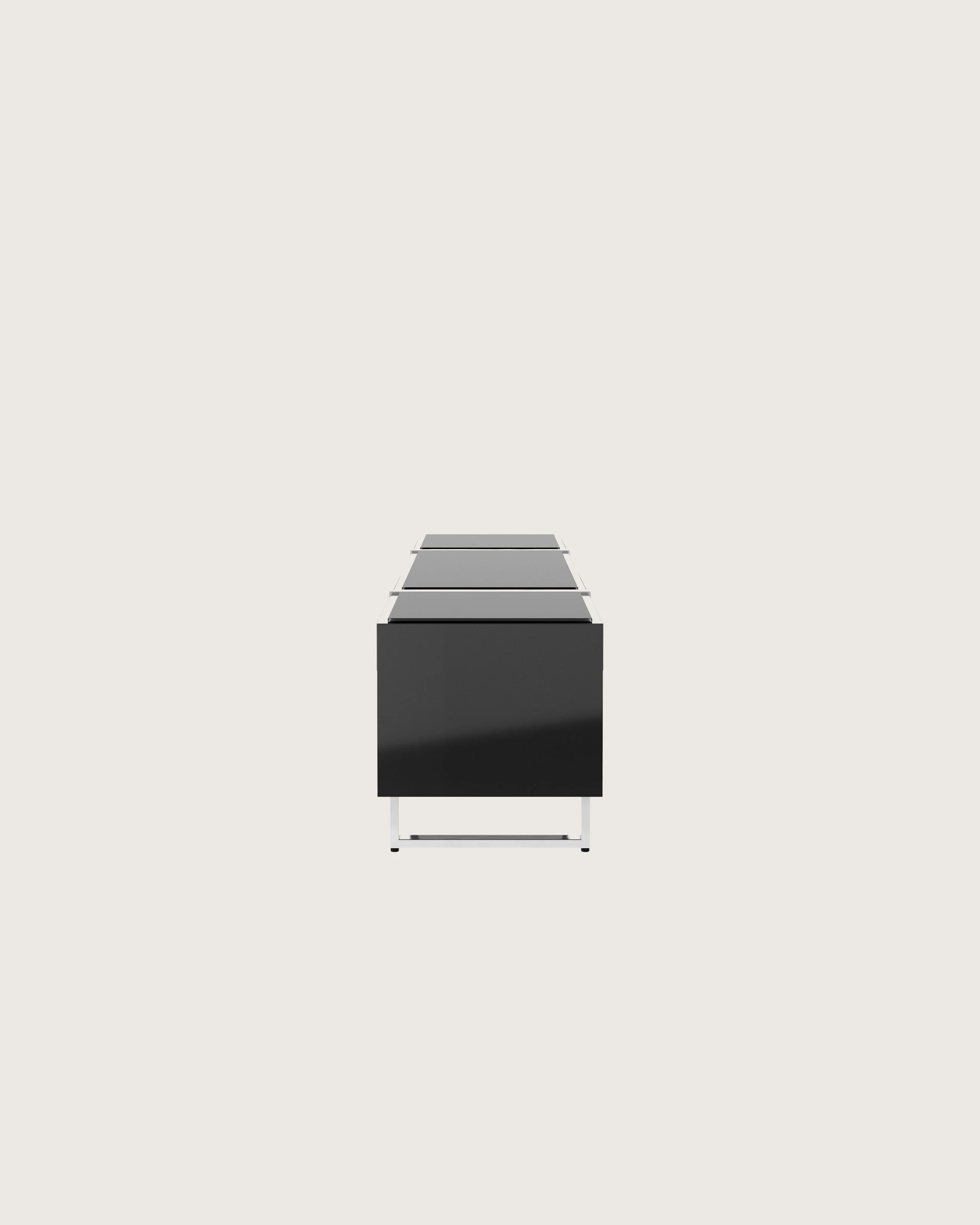 Highline Credenza in Black Polyester with Clear Black Backpainted Glass top and Polished Chrome legs viewed from the side.
