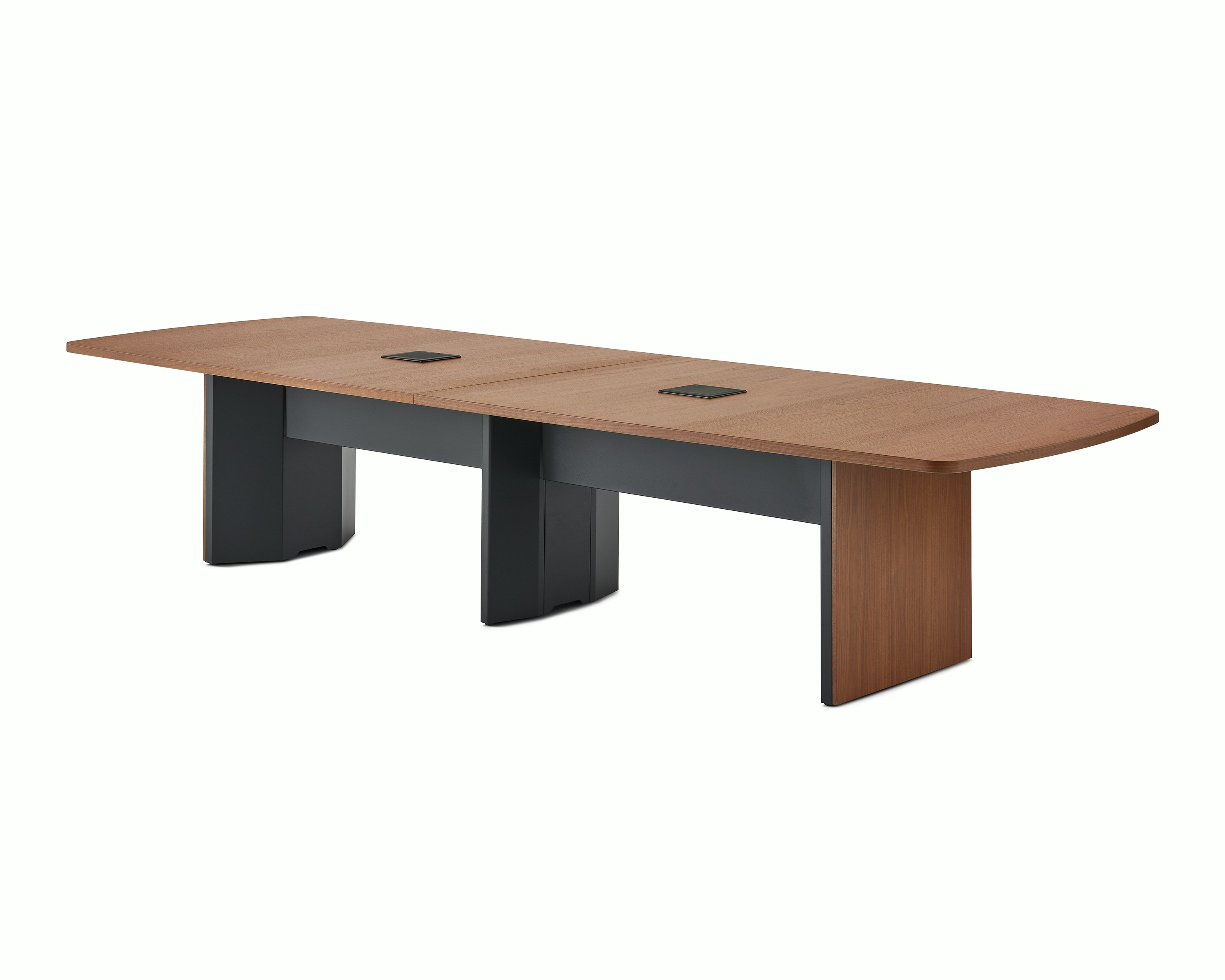 A medium walnut cabinet base Headway conference table viewed at an angle with a black tech curtain underneath.