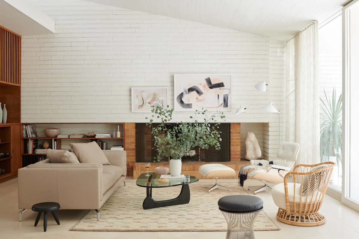 Modern living room with beige sofas, marble coffee table, and plants