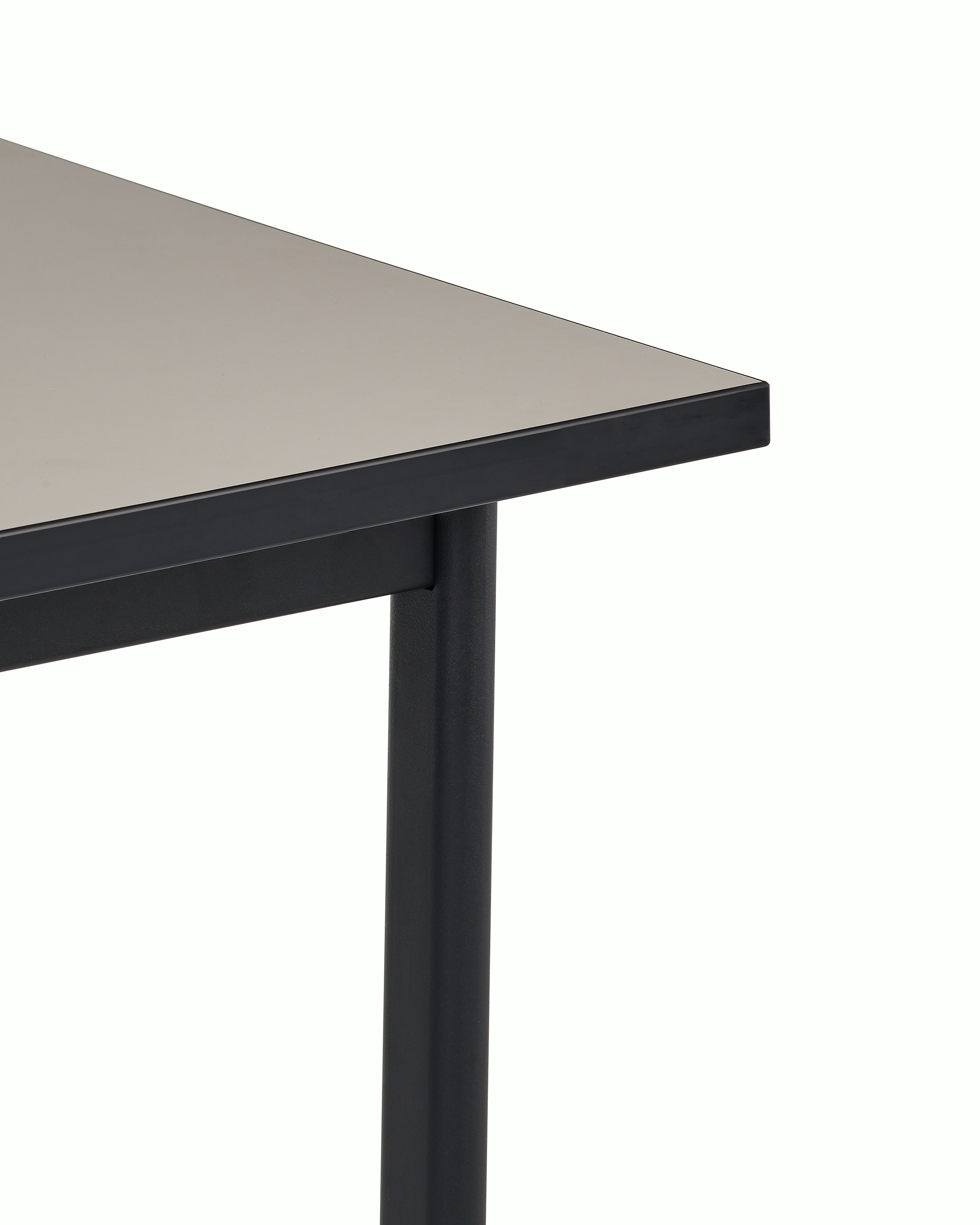 Detail view of the sandstone laminate top on a black Mode desk.