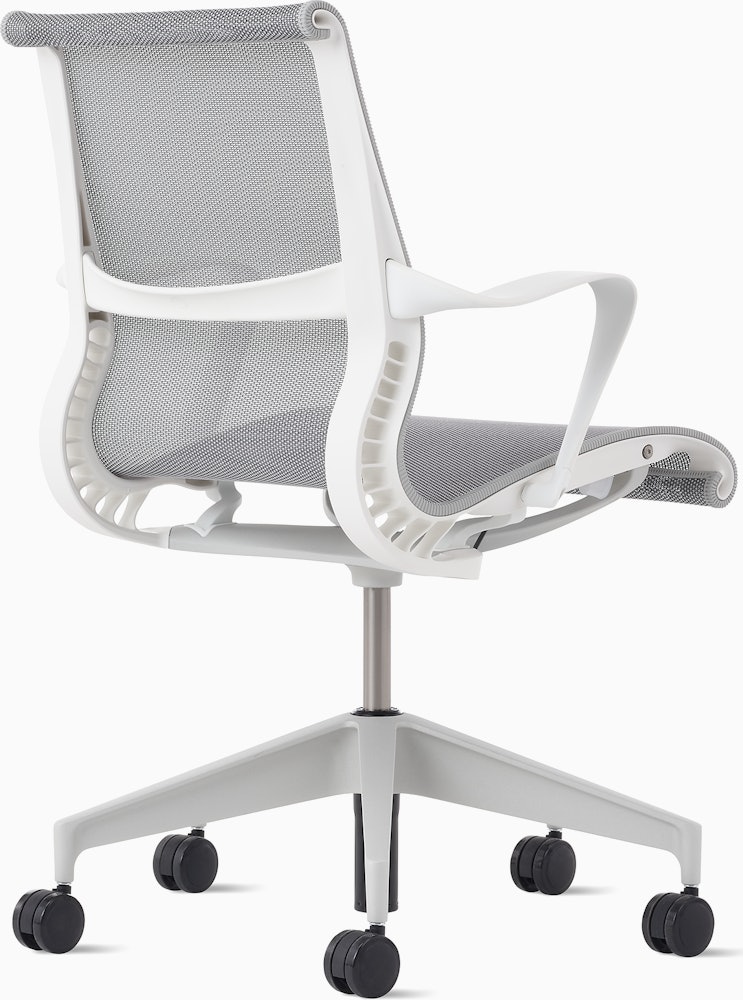 Rear angle view of a Setu chair with grey suspension, white frame and silver alloy base.