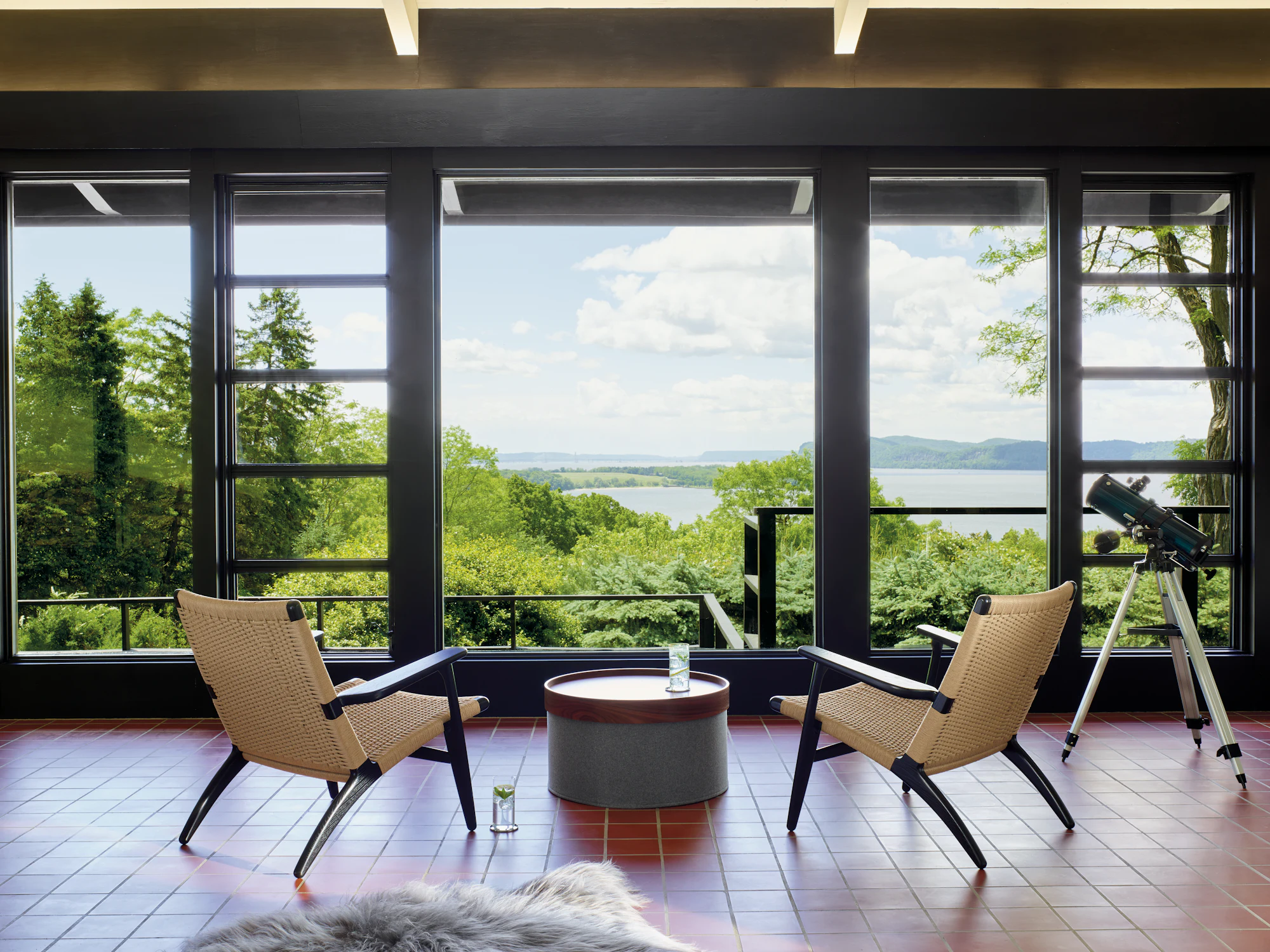 Grey drum pouf used as an outdoor seating piece with chairs and a round side table