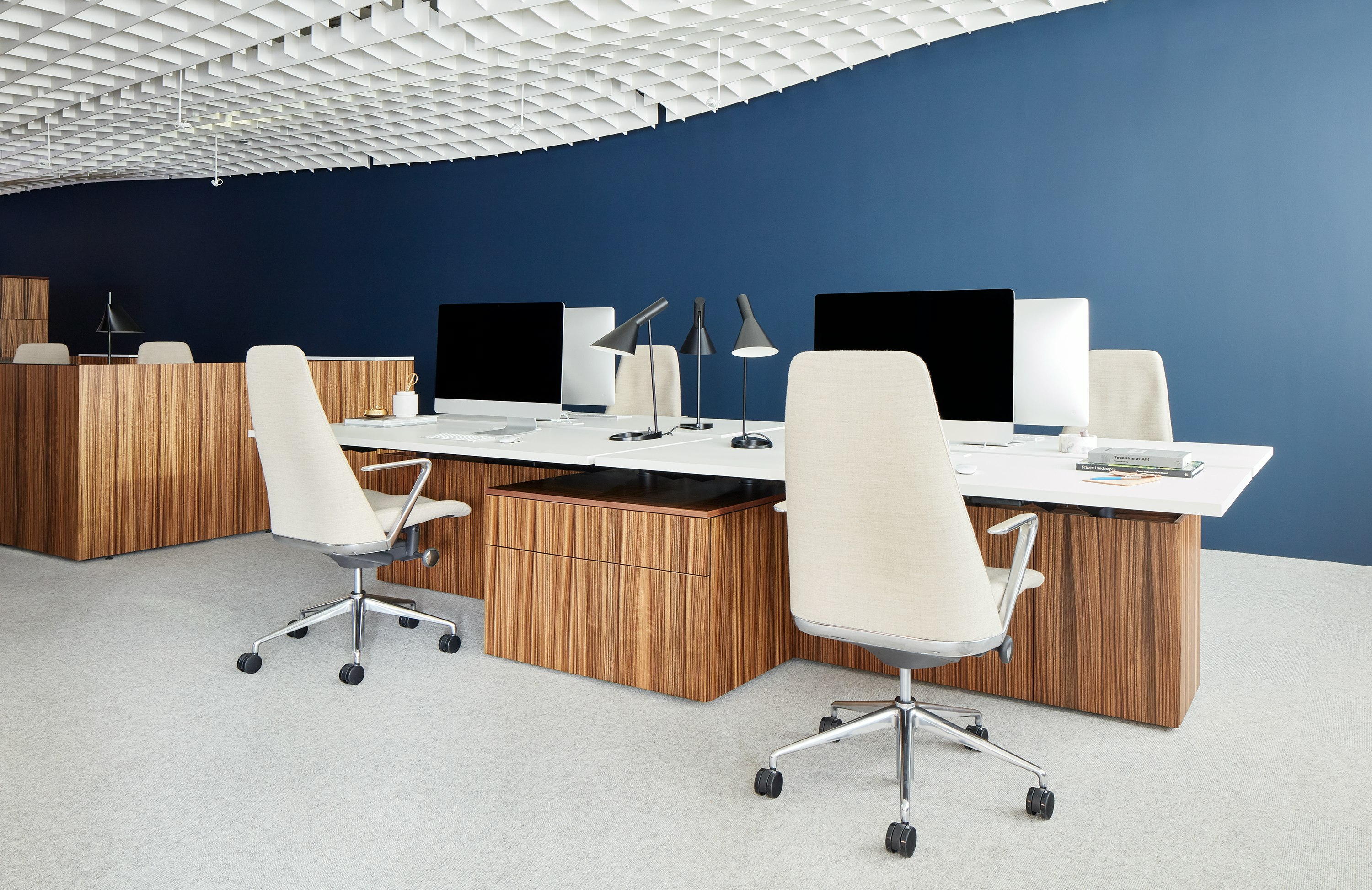 A bench system with four workstations featuring Geiger One Casegoods and Taper Chairs.