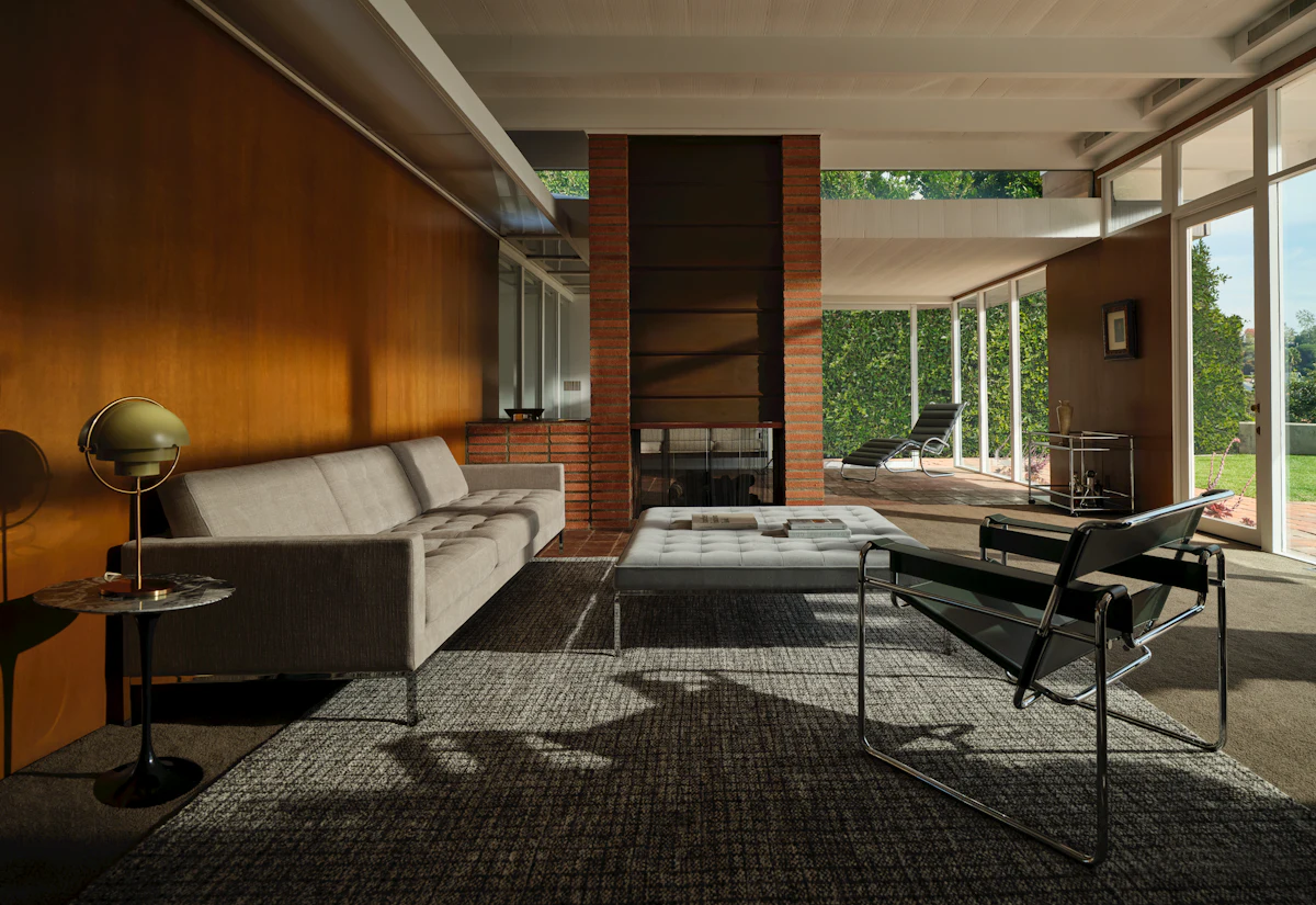 Black tufted two-seat sofa with metal legs.