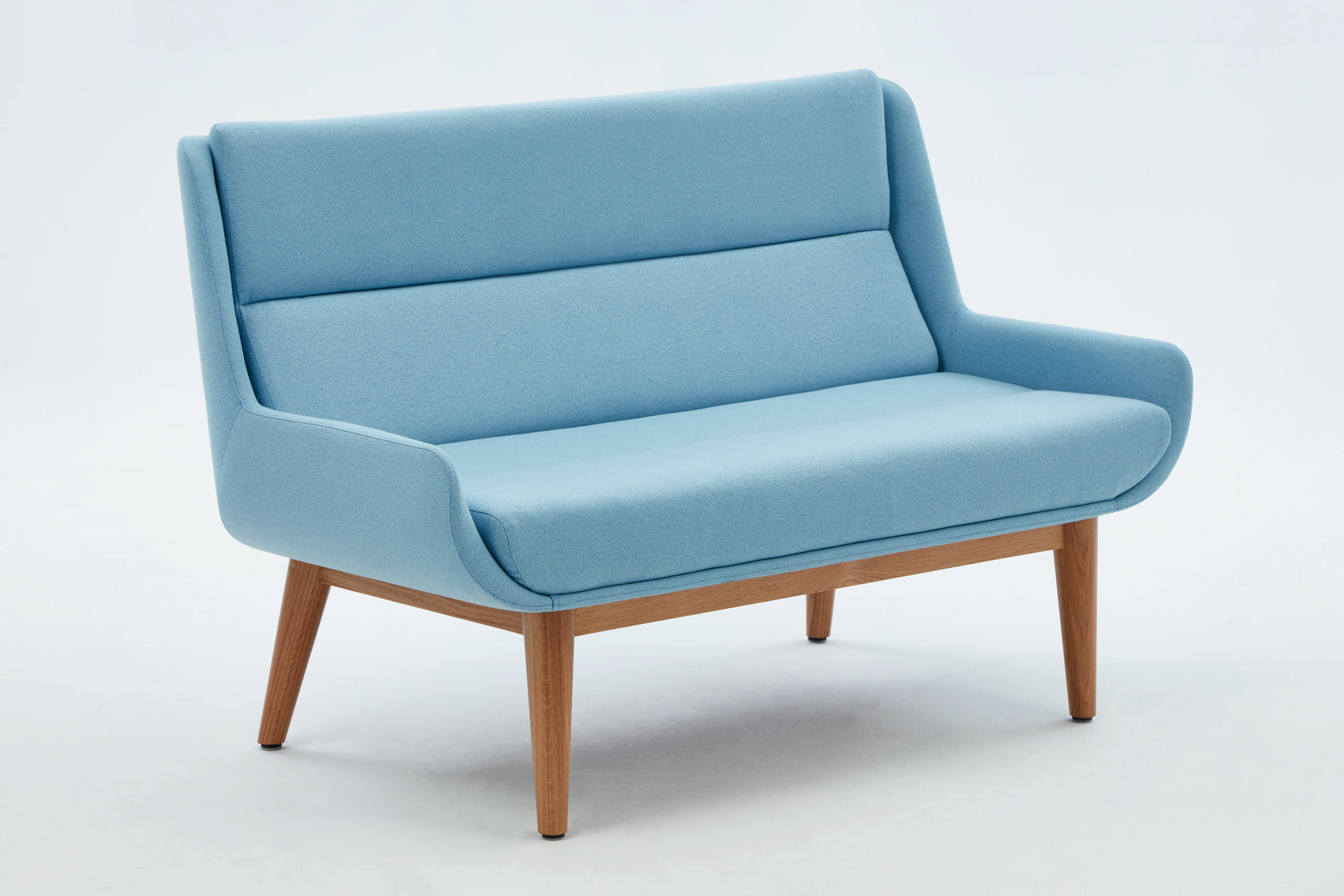 White sweep shot of pale blue Hush Low Sofa with oak legs.