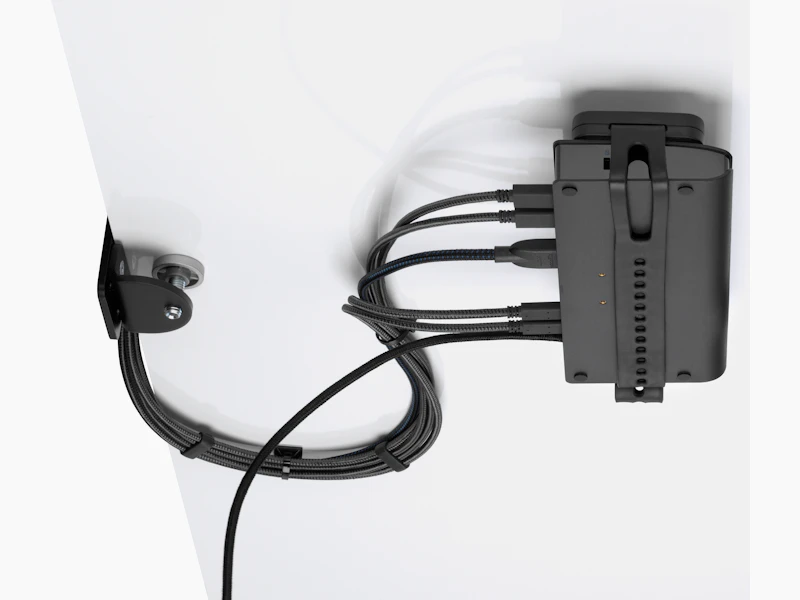 Loop Micro Mount attached under a desk cradling a thin client or power docking station with attached cables that are routed tidily to the edge and above the desk.