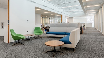 Group collaboration space in an academic research institute with lounge seating adjacent to workstations.