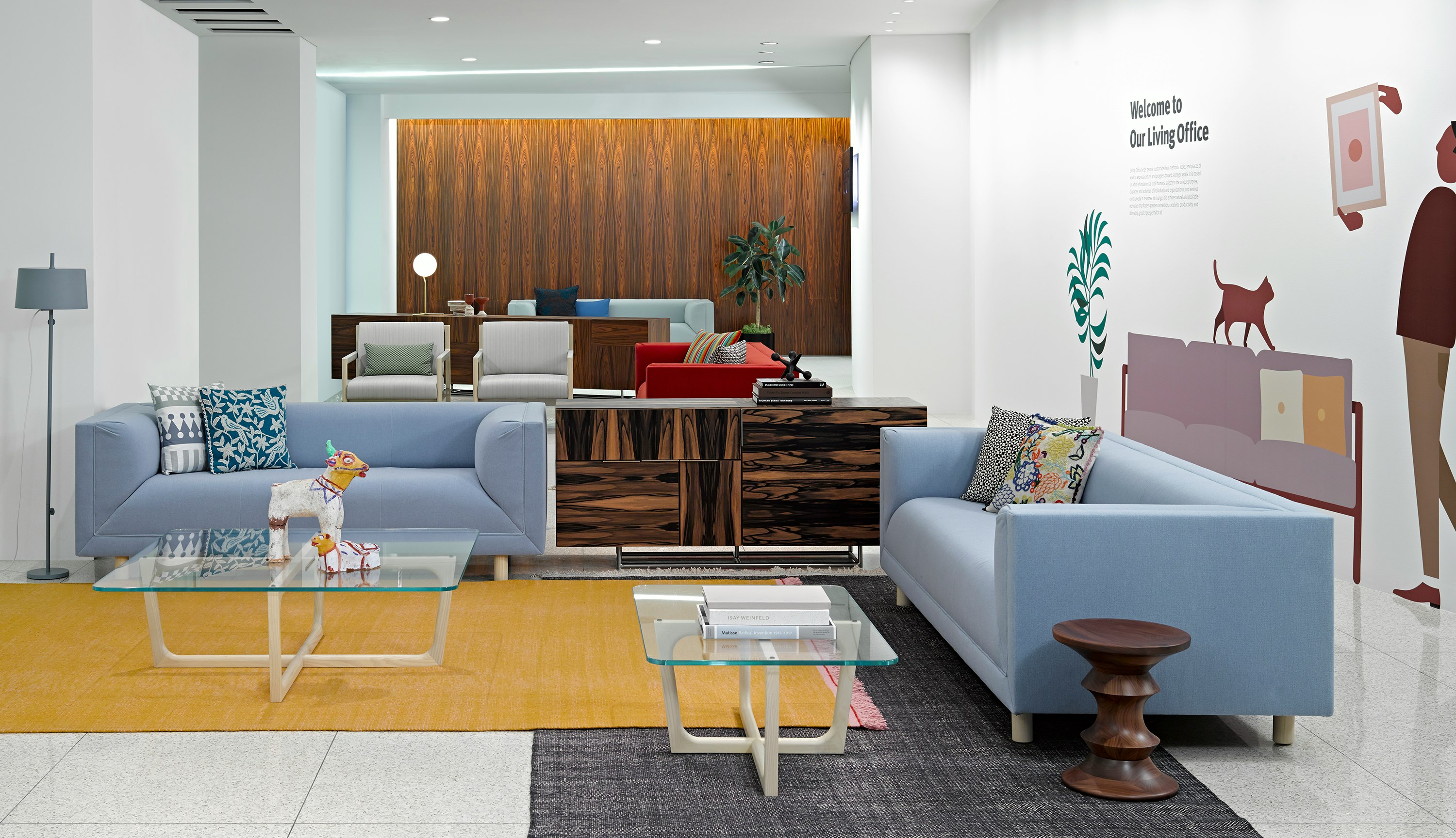 A lounge featuring two Brabo club chairs with ivory-colored upholstery and four Rolled Arm sofas in various colors.