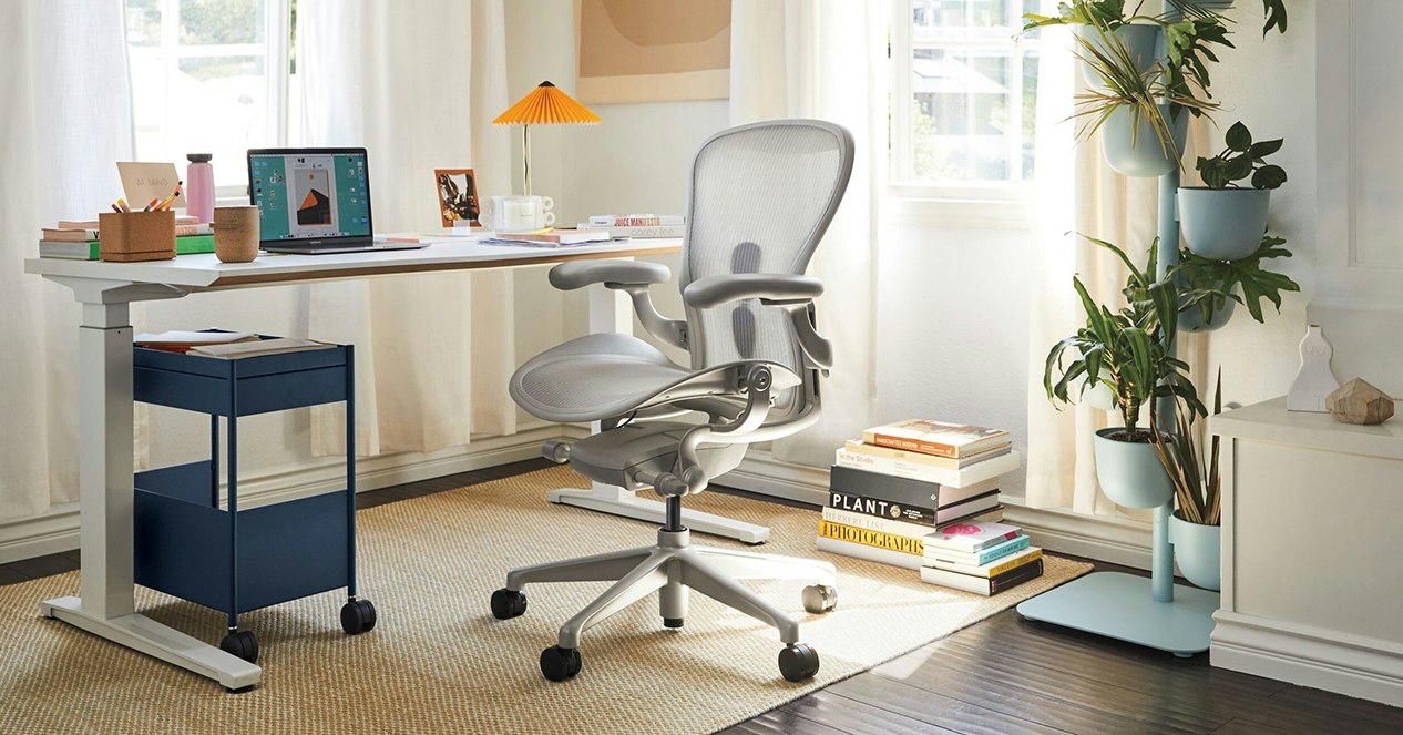 An Aeron Chair with a mineral, polished aluminum finish with a Renew Desk, in a home office.