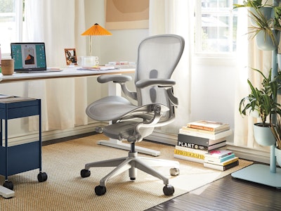 An Aeron Chair with a mineral, polished aluminum finish with a Renew Desk, in a home office.