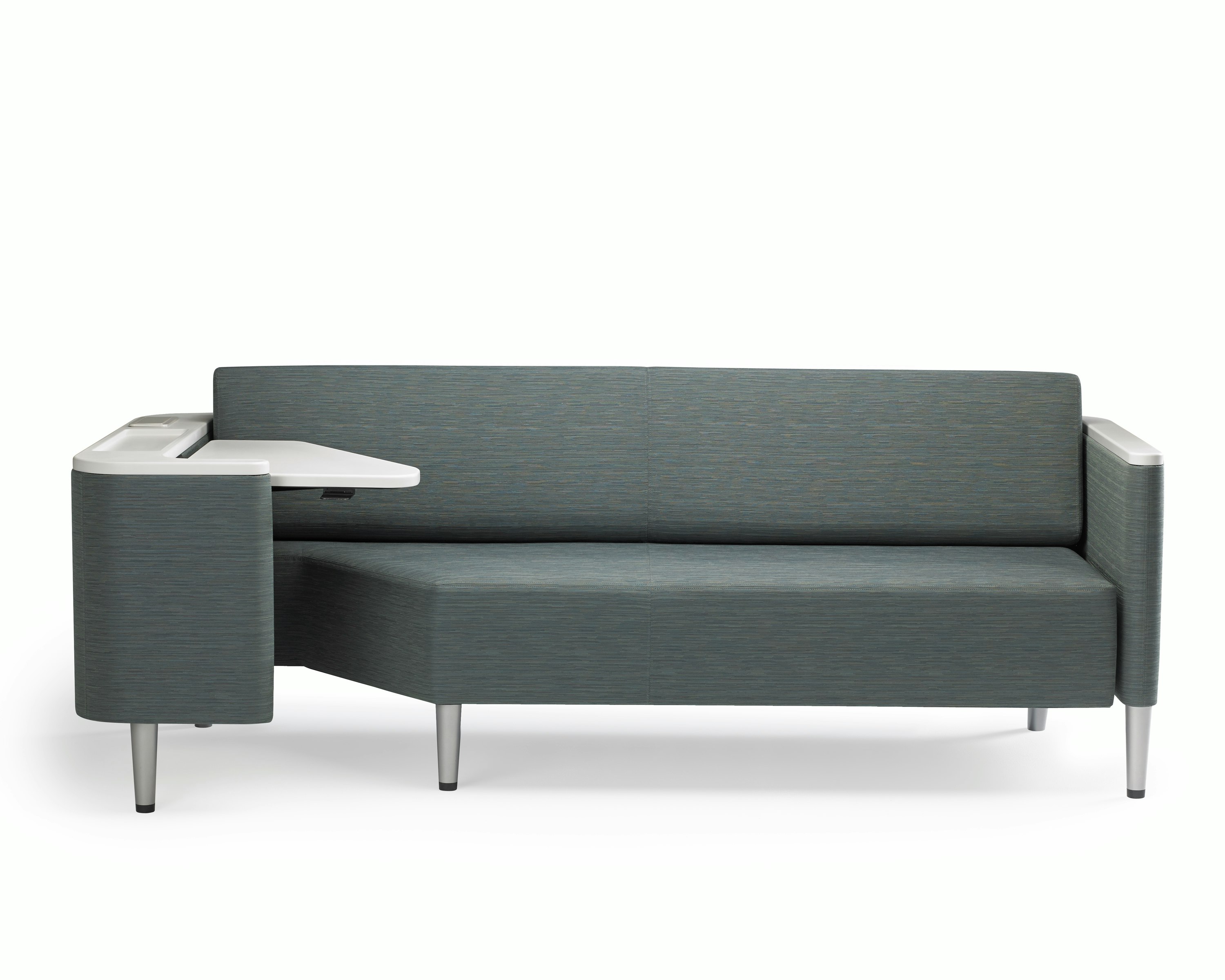 A Palisade Flop sofa in dark grey textile with white solid surface arms caps and white adjustable table with Durawrap top.
