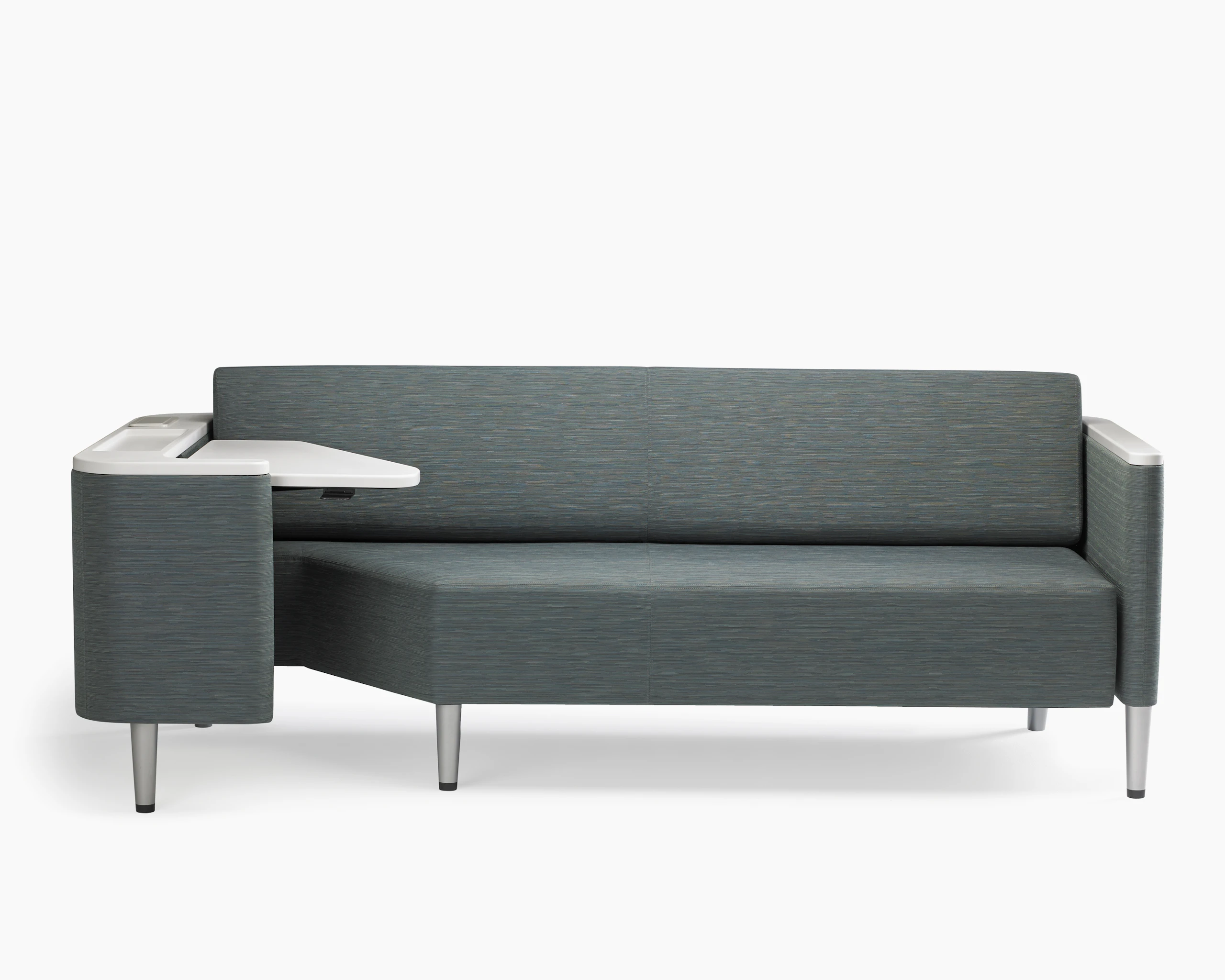 A Palisade Flop sofa in dark grey textile with white solid surface arms caps and white adjustable table with Durawrap top.