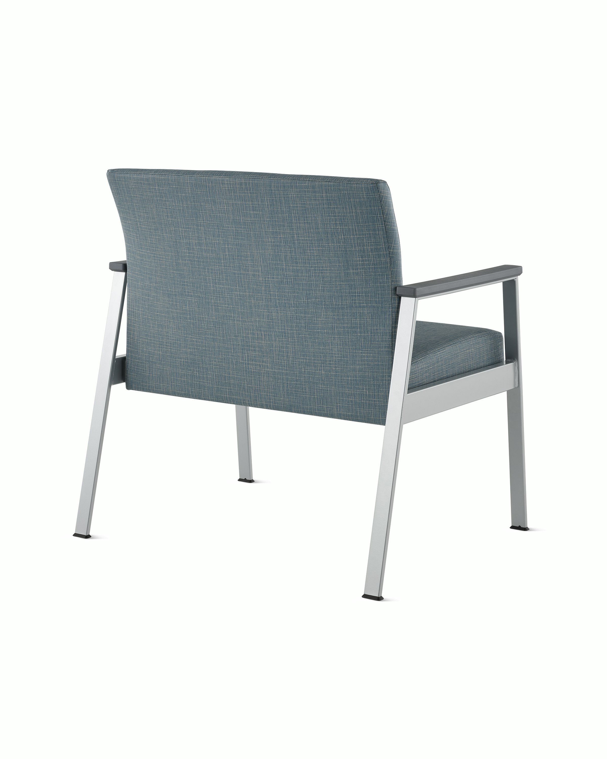 Rear angle view of an Easton Plus Chair with blue upholstery, metallic four leg base and slate grey arm caps.