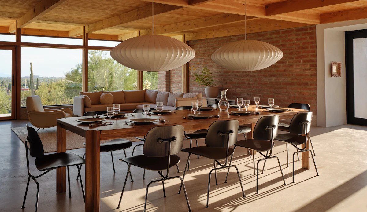 Large wooden dining table with chairs and pendant lights in a modern dining room