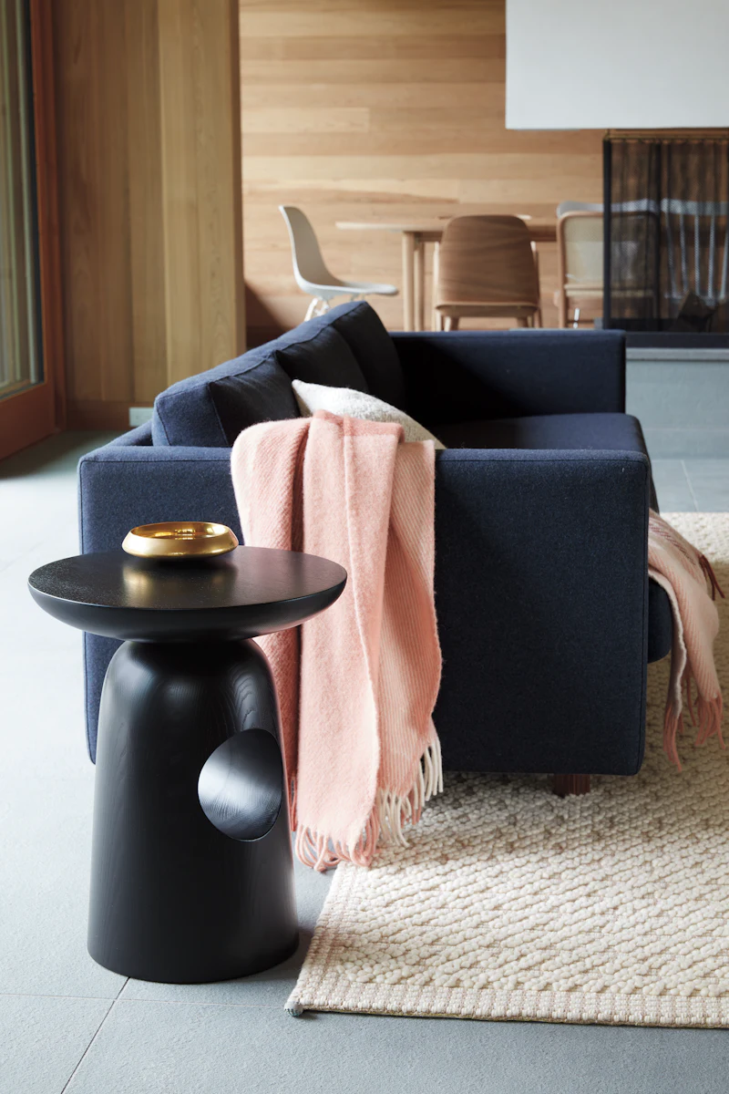 Modern gray sofa with pink throw blanket and a glass coffee table