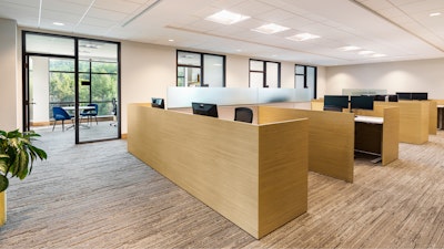 An open office area featuring several individual workstations furnished with Knoll Life Chairs