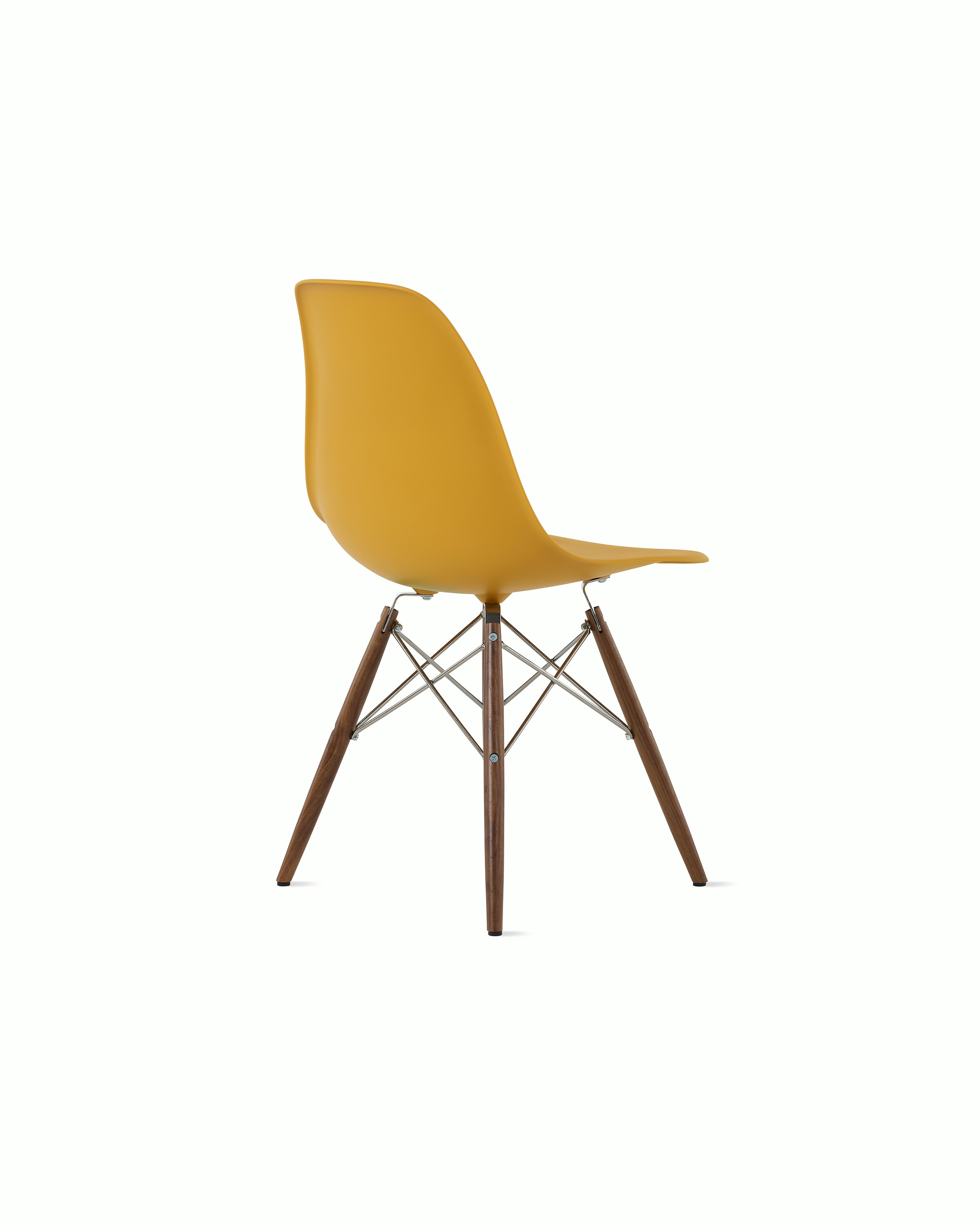 Back of deep yellow plastic shell chair on dowel-base legs.