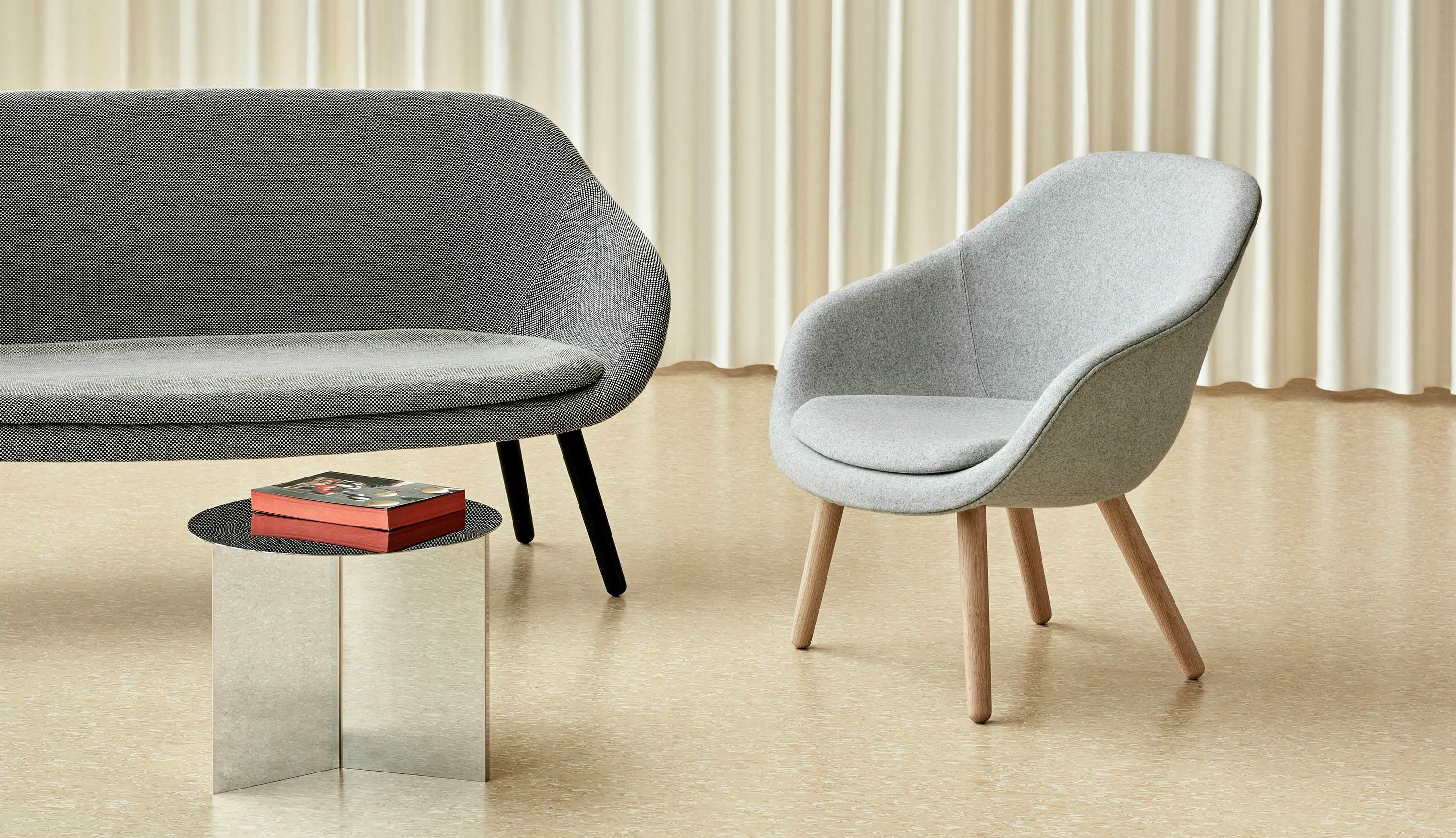 A grey About A Lounge Sofa with black legs next to a light grey About A Lounge 82 Chair.