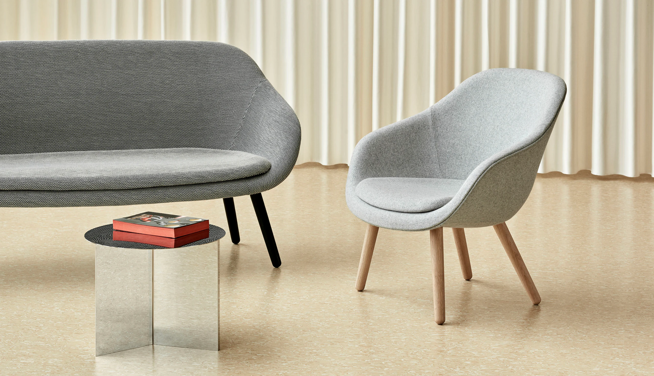 A grey About A Lounge Sofa with black legs next to a light grey About A Lounge 82 Chair.